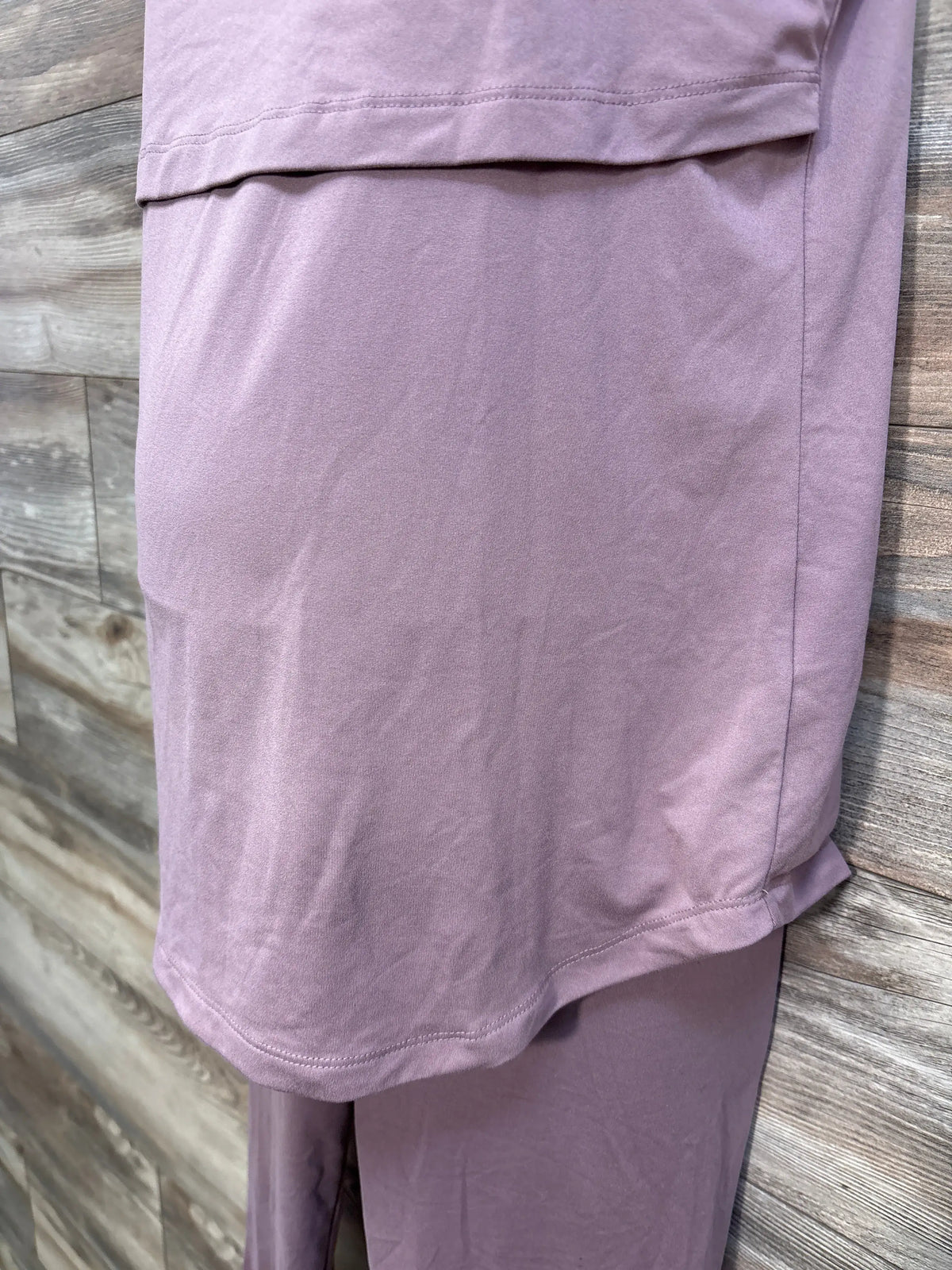 Close up of pink Kindred Bravely two piece nursing tank top and shorts set showing stitched hems on a wood look floor