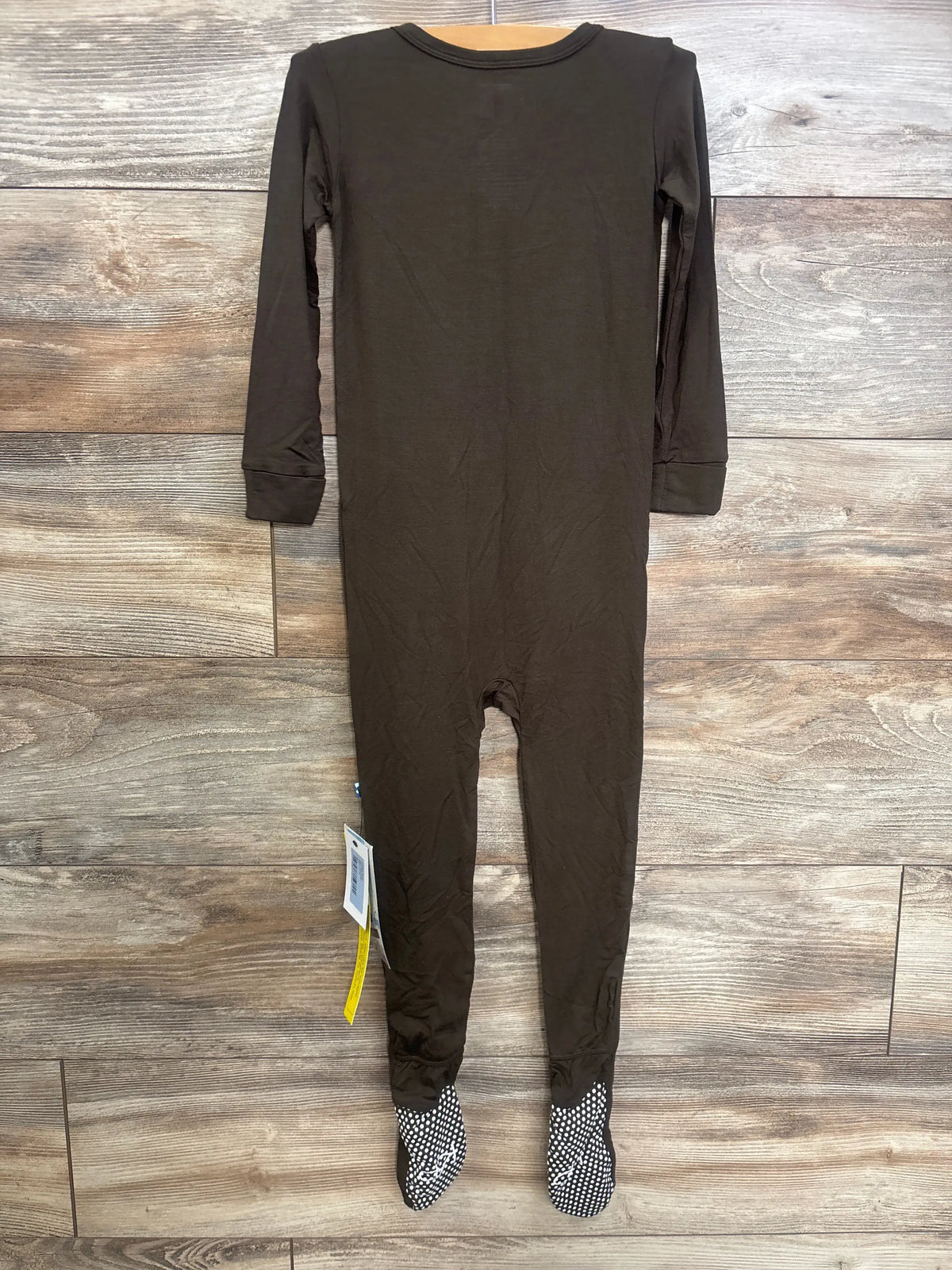 Front view of Kickee Kids snap footie in Bark Brown with long sleeves, attached dotted feet, and wood-grain background