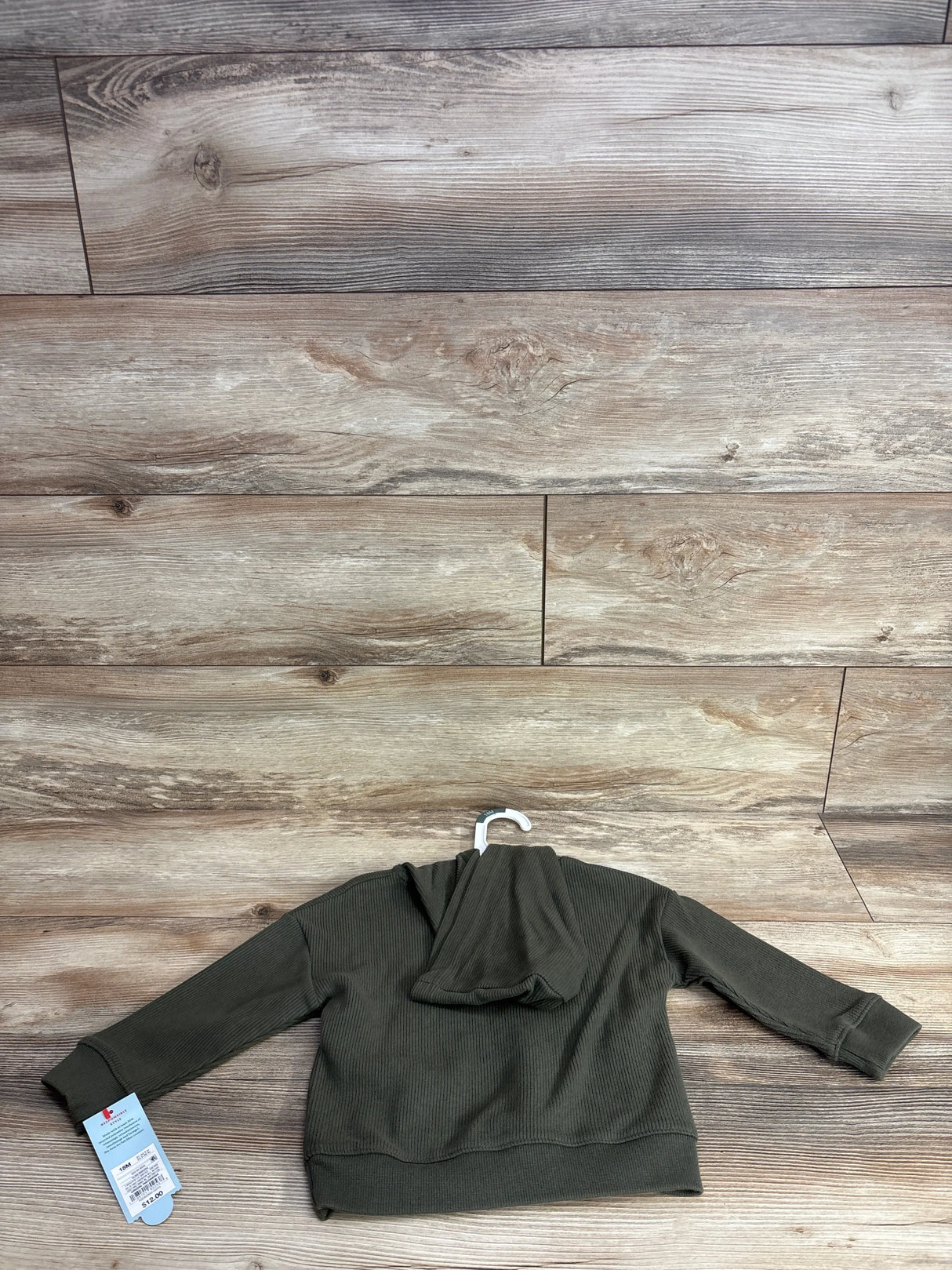 Olive green ribbed toddler hoodie on hanger, long sleeves, wooden background