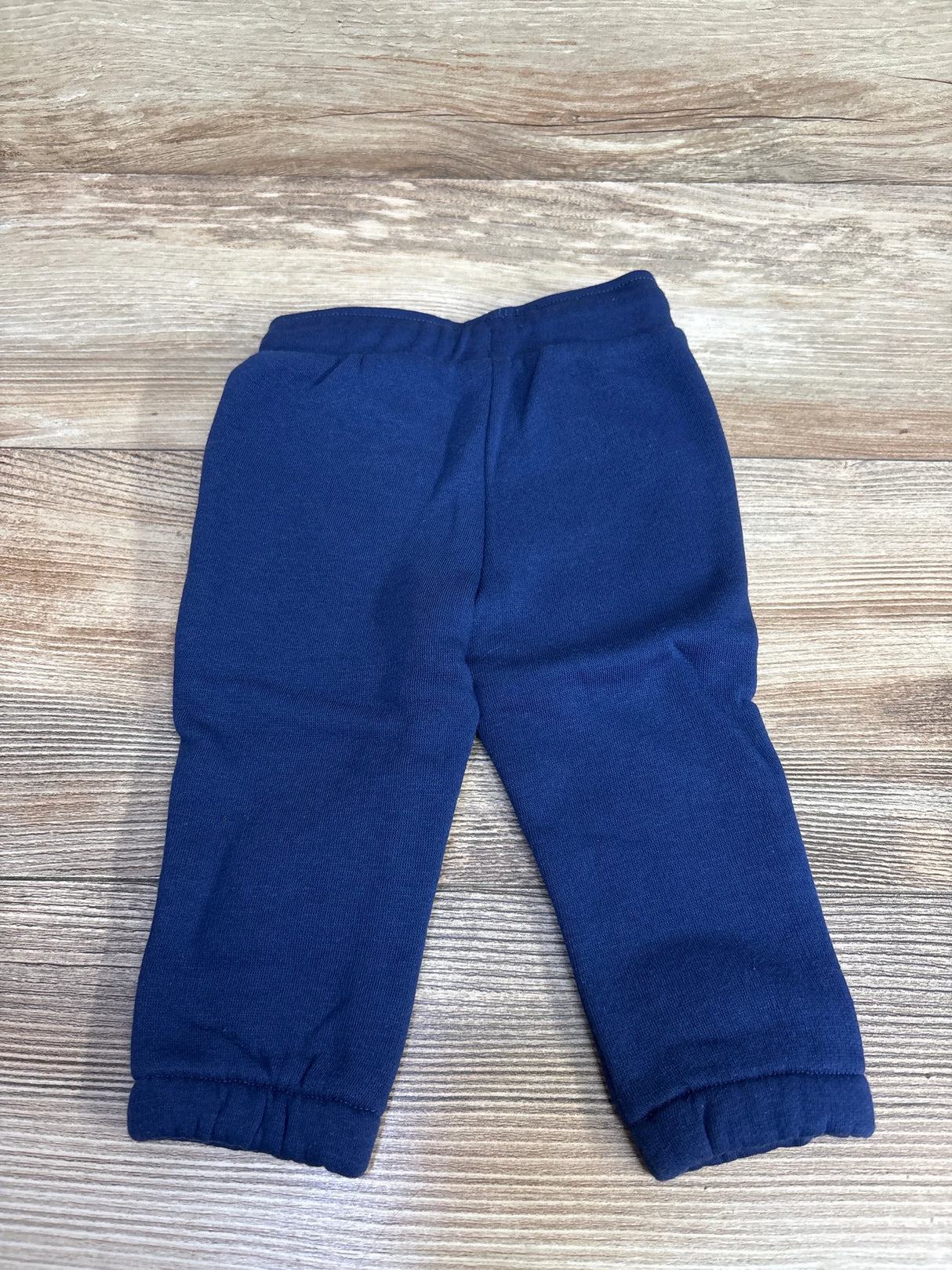 Navy blue elastic waist baby pants on wooden surface, soft kids clothing