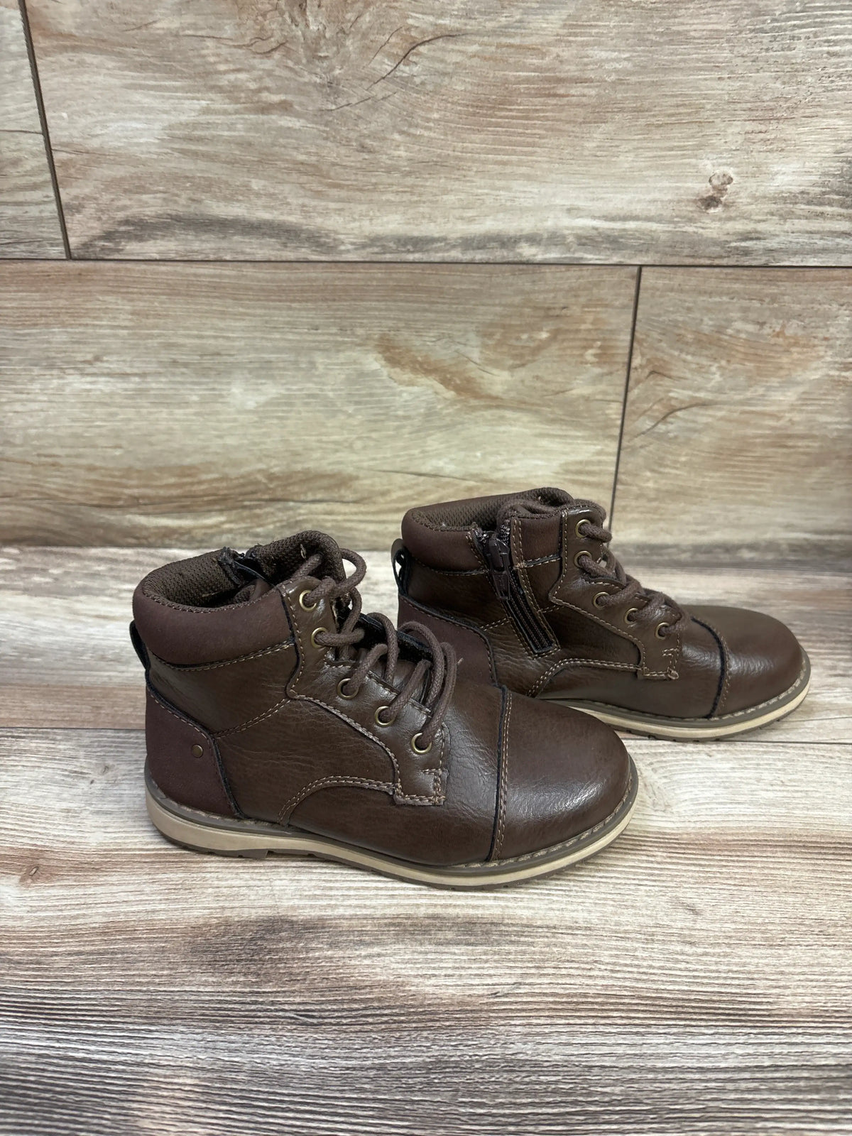 Three-quarter view of Sonoma Goods for Life Joshua lace-up boots showcasing side zippers and padded collars on a wood floor