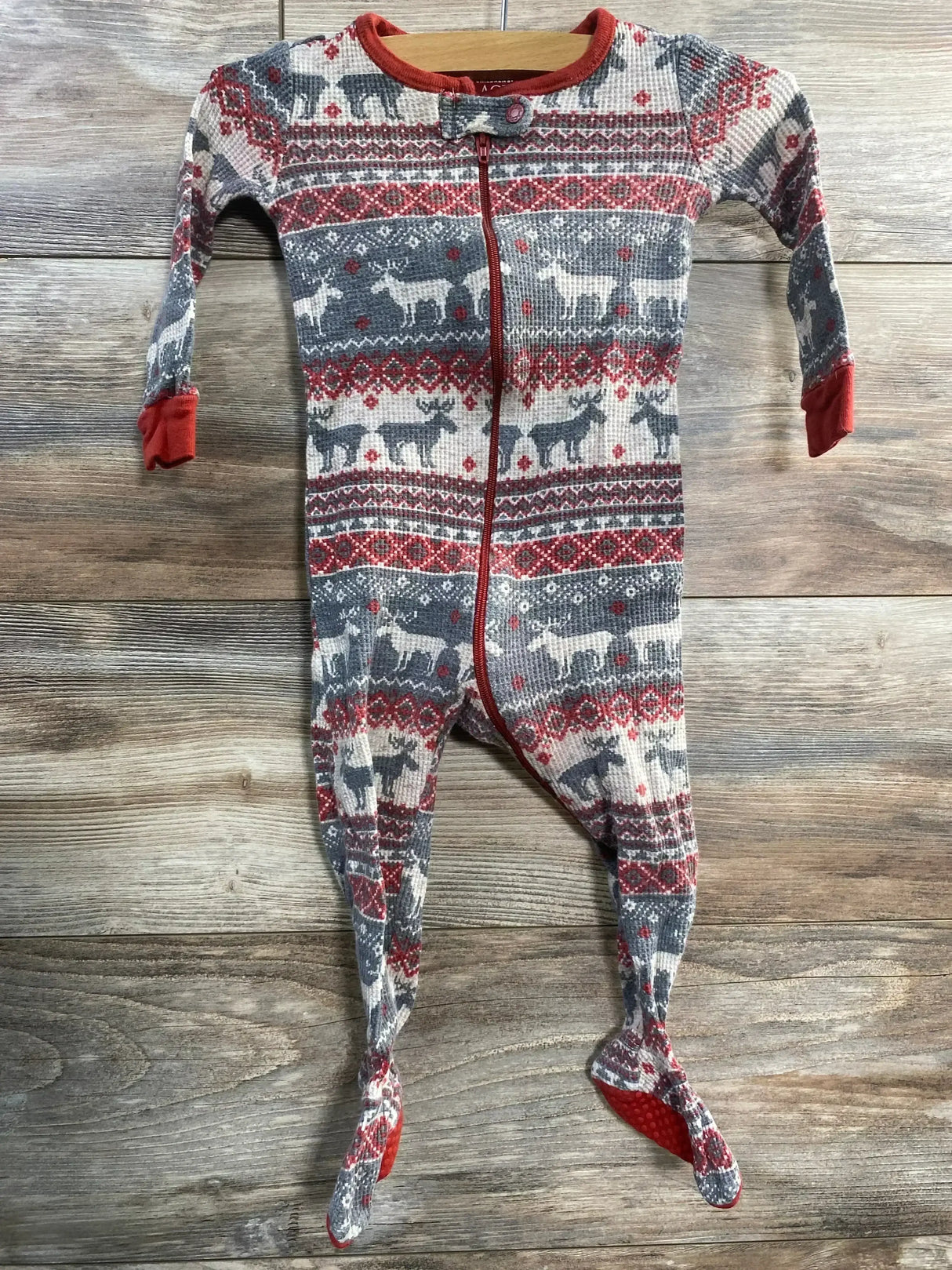 Front view of Children's Place grey Fair Isle footed sleeper (9–12m) with red trim, front zipper, and non-slip soles on wood background