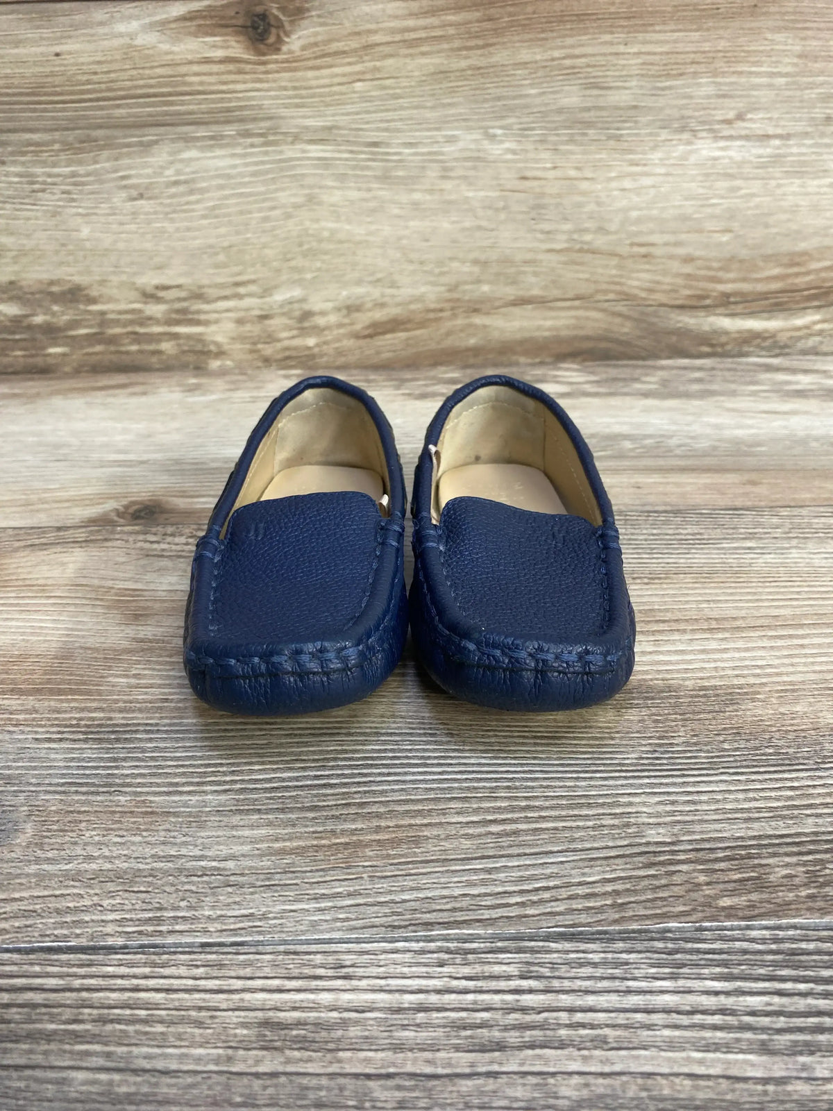 Front view of Janie and Jack navy leather driving shoes, toddler size 8C, showing stitched moc toe on wood-look background