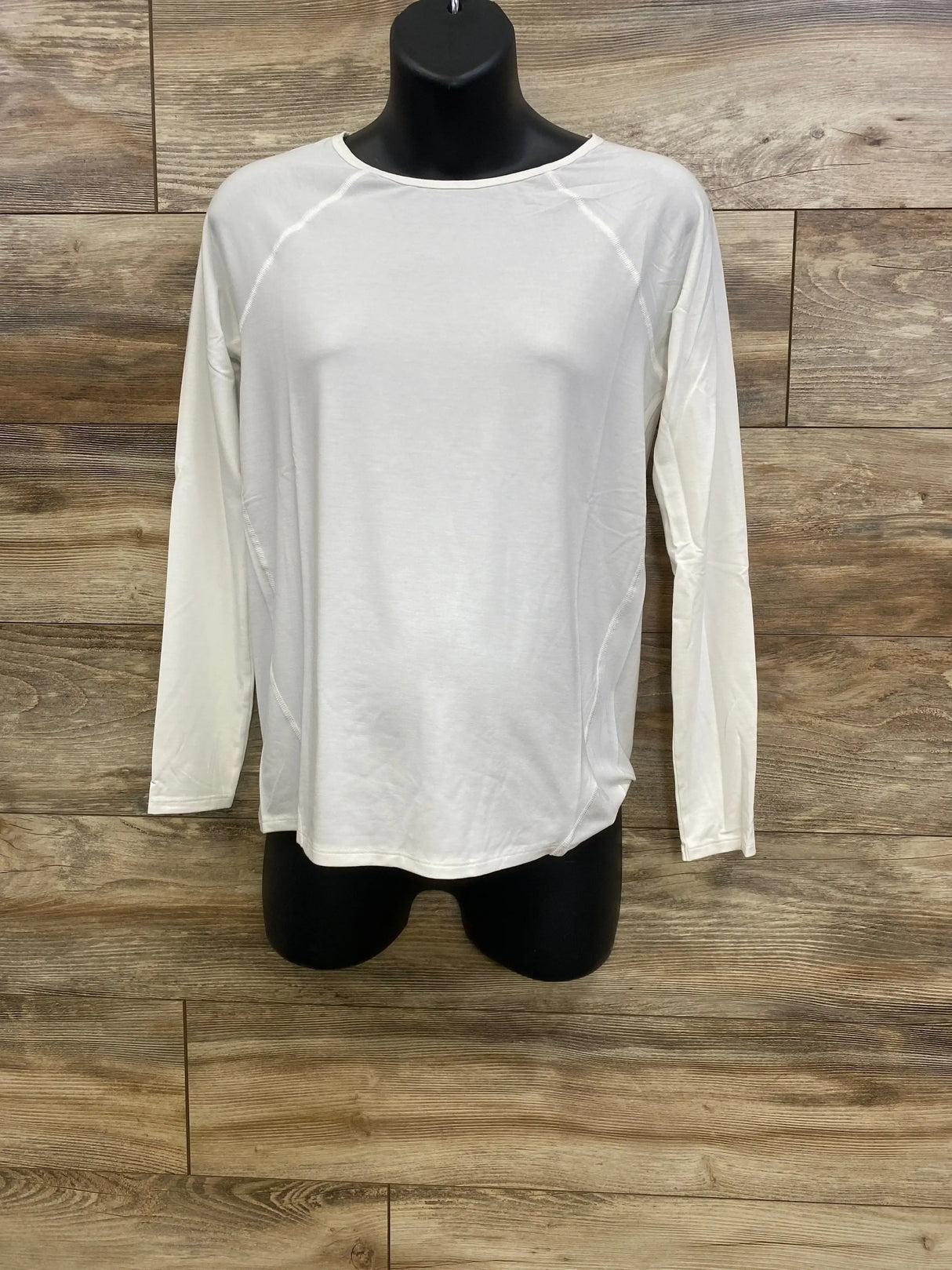 Front view of NWOT Gap Maternity Breathe long sleeve shirt in white showcasing crew neck and raglan stitching on black mannequin over wood plank floor