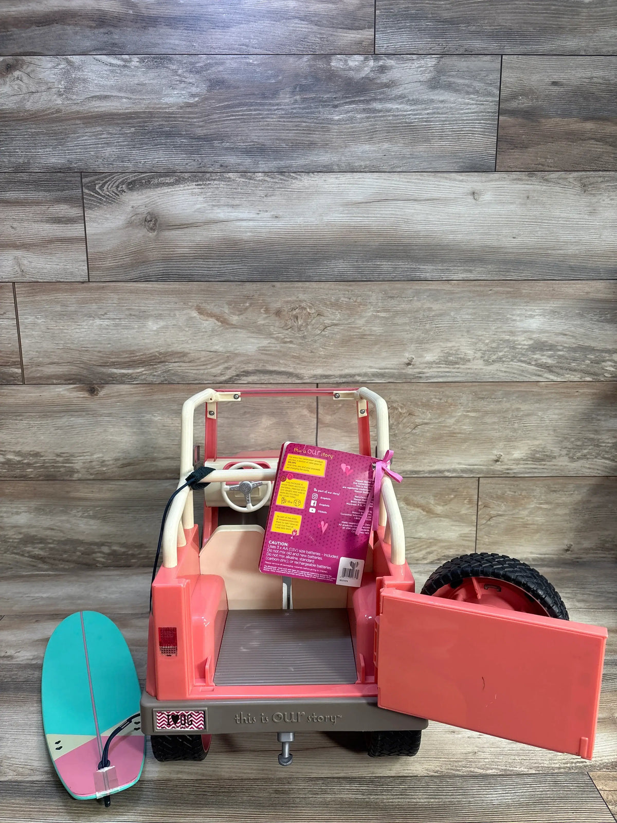 Rear view of pink Our Generation Off-Roader 4x4 doll vehicle with open side door, roll bars, spare tire, and cargo area