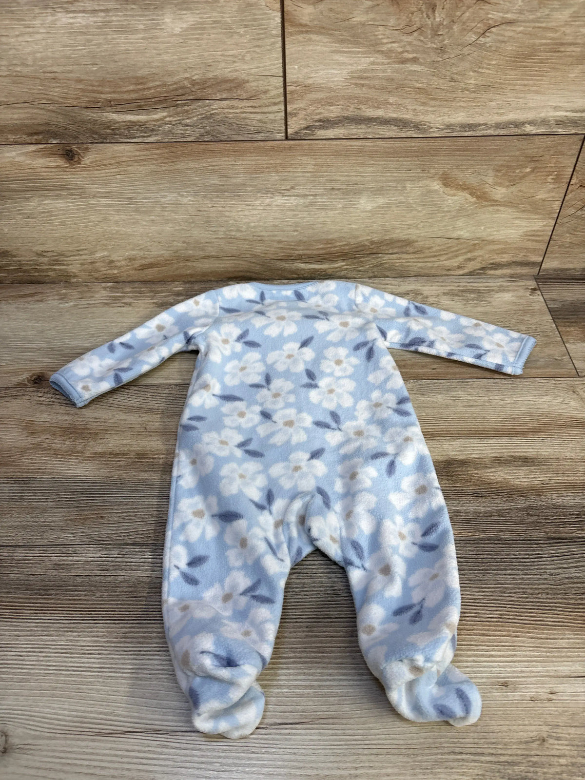 Front view of Just One You blue 3M blanket sleeper showcasing floral pattern, long sleeves, and footed design on a wood floor