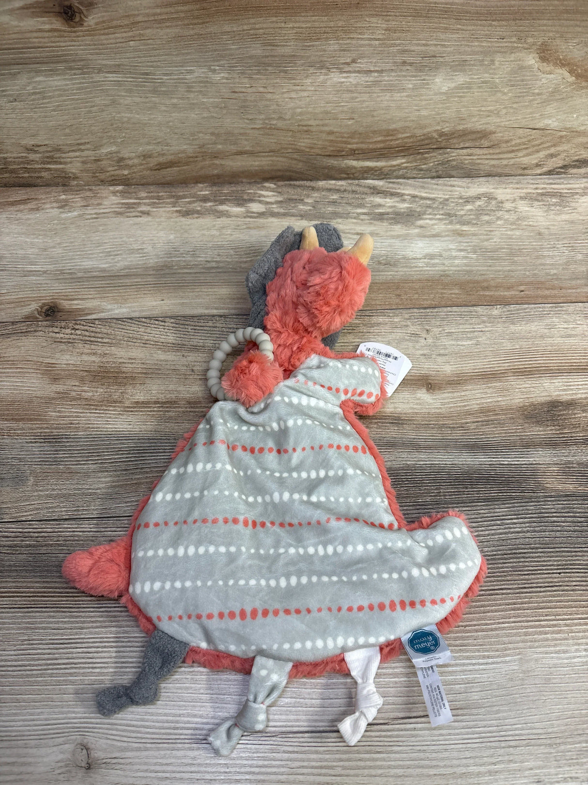 Plush animal security blanket with striped pattern and knotted corners on wood background