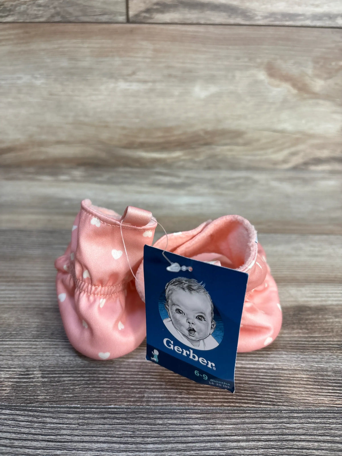 New pink baby booties with white heart print and Me n Mommy To Be brand tag.