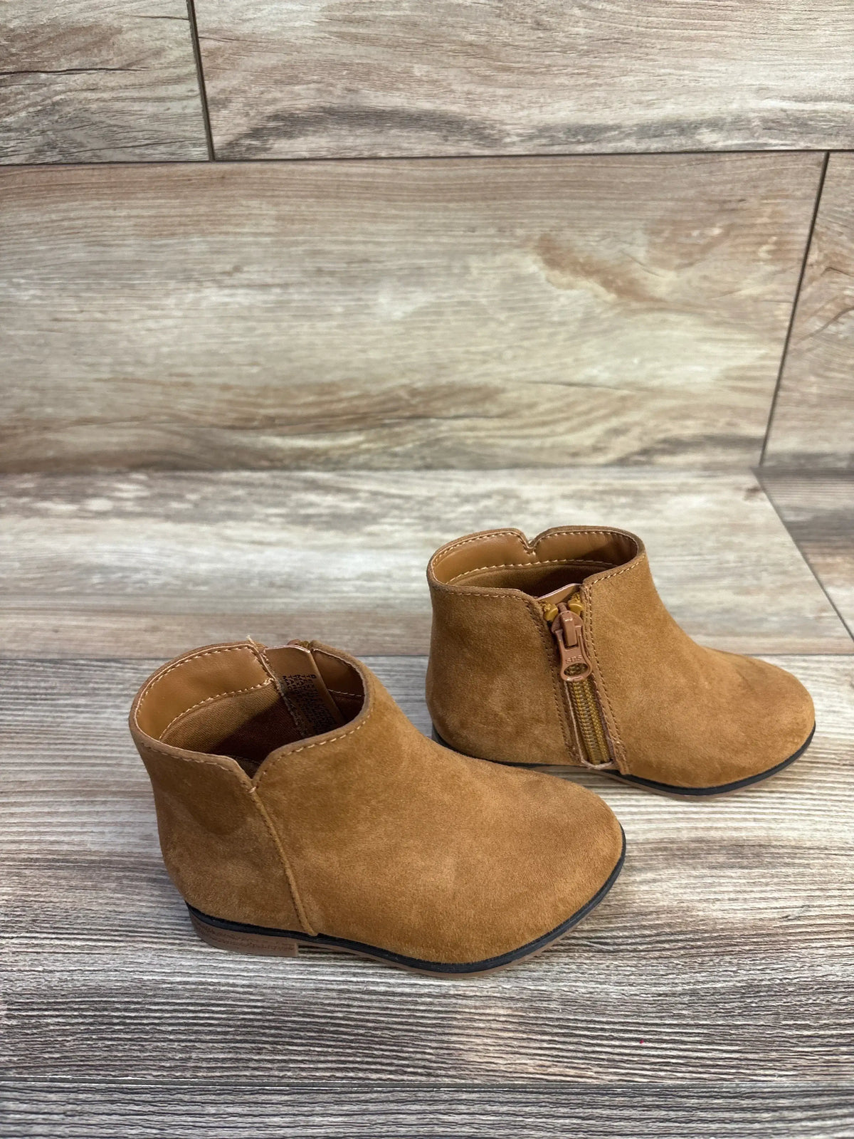 Front and side view of Cat & Jack Penelope brown boots showcasing side zippers on wood-look flooring