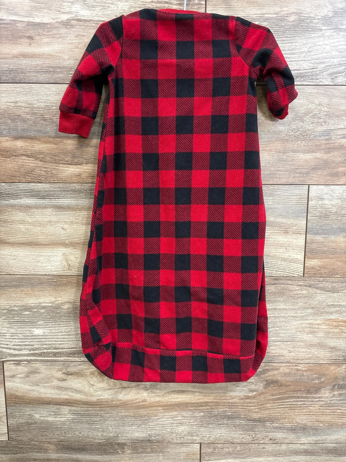 Flat-lay of Carter’s red and black buffalo plaid fleece sleep sack 9-12m with sleeves and rounded bottom on wood floor