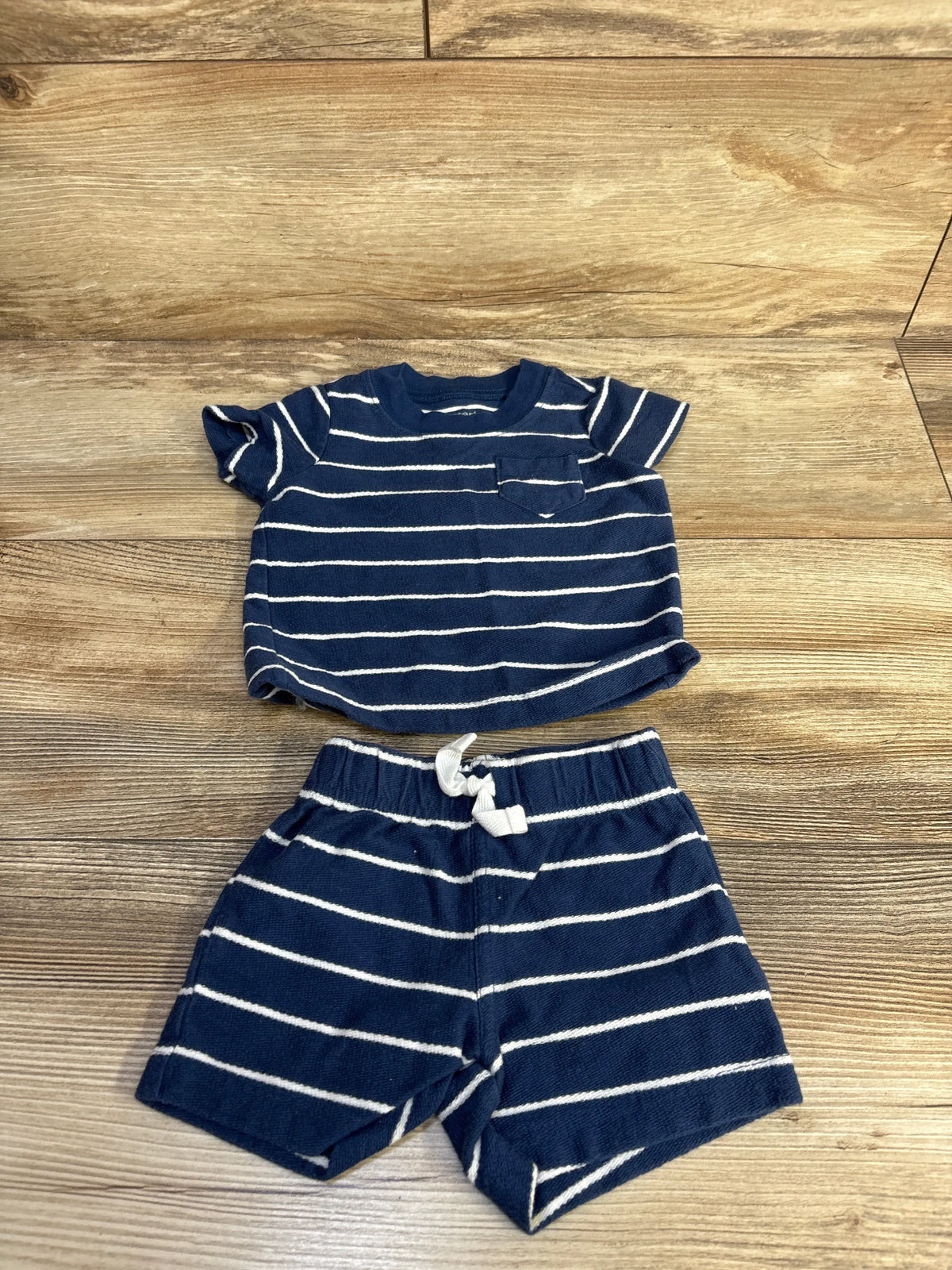 Top view of Just One You navy striped shirt and shorts set showcasing chest pocket and drawstring waist on wood