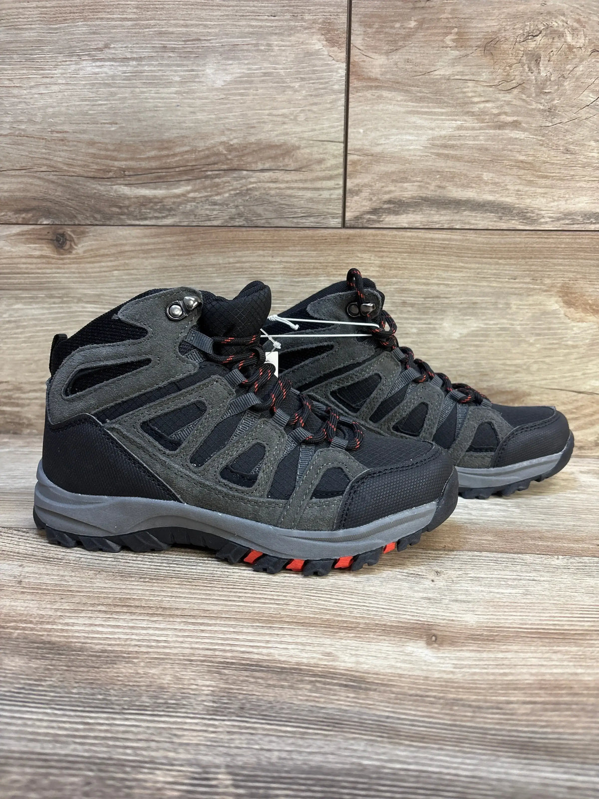 Side view of Cat & Jack Patsy kids hiking boots size 4Y in black and gray, showing red-accented laces and rugged tread on wooden background