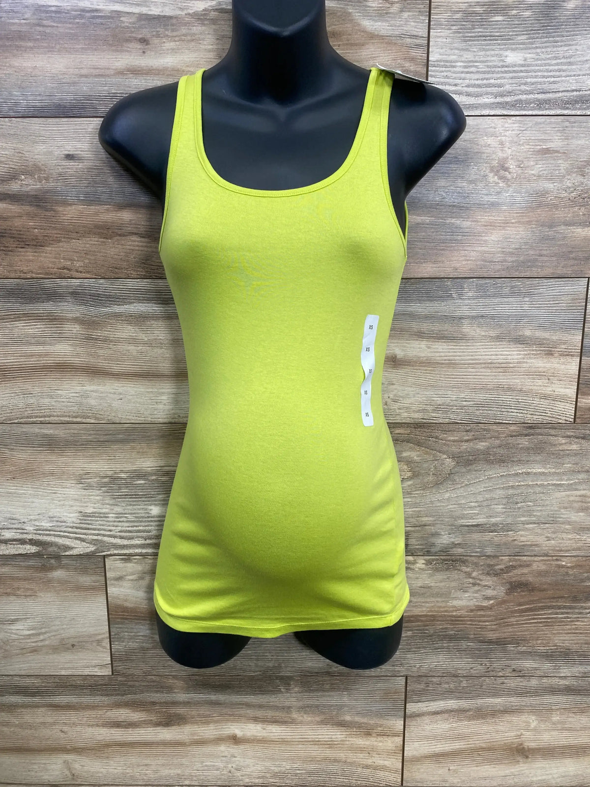 Front view of Isabel maternity tank top showcasing fitted stretch over baby bump on black mannequin with wood plank background