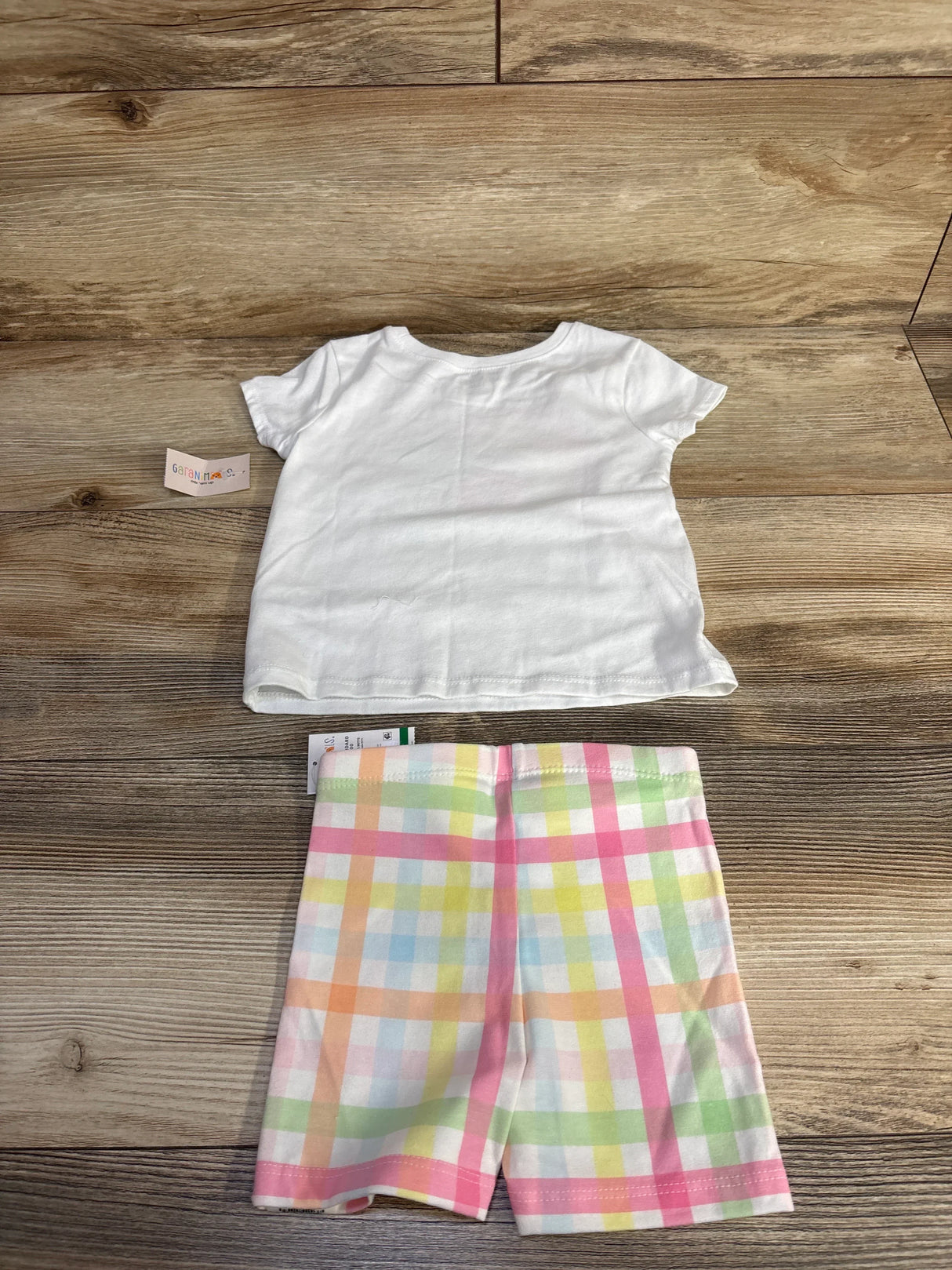 Top down flat lay of white toddler tee and pastel plaid shorts, 18mo, showing elastic waistband on wood background