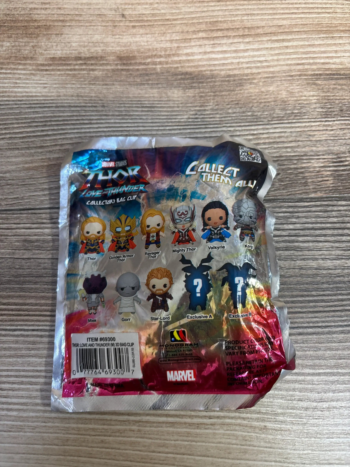Front of Marvel Thor Love and Thunder blind bag showing character checklist and Collect Them All headline on wood background