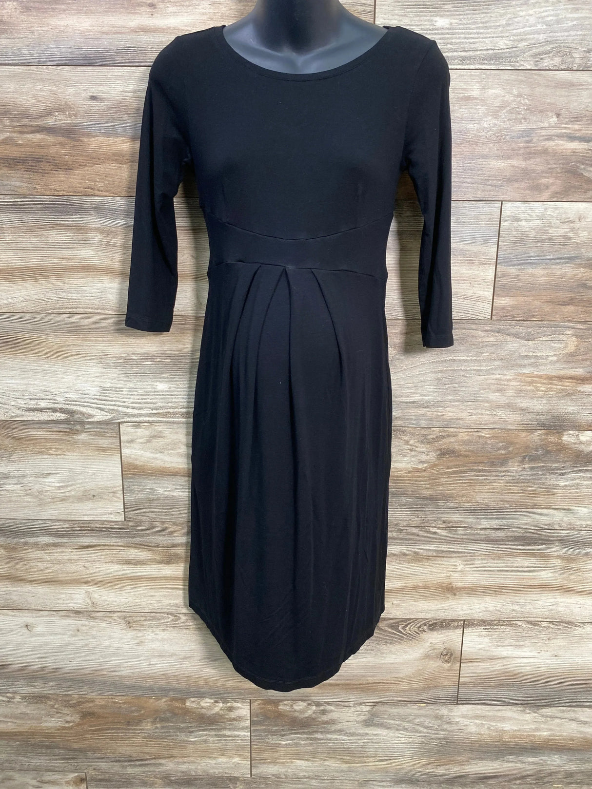 Front view of Isabella Oliver black maternity dress on mannequin showing three quarter sleeves empire waist and front pleats