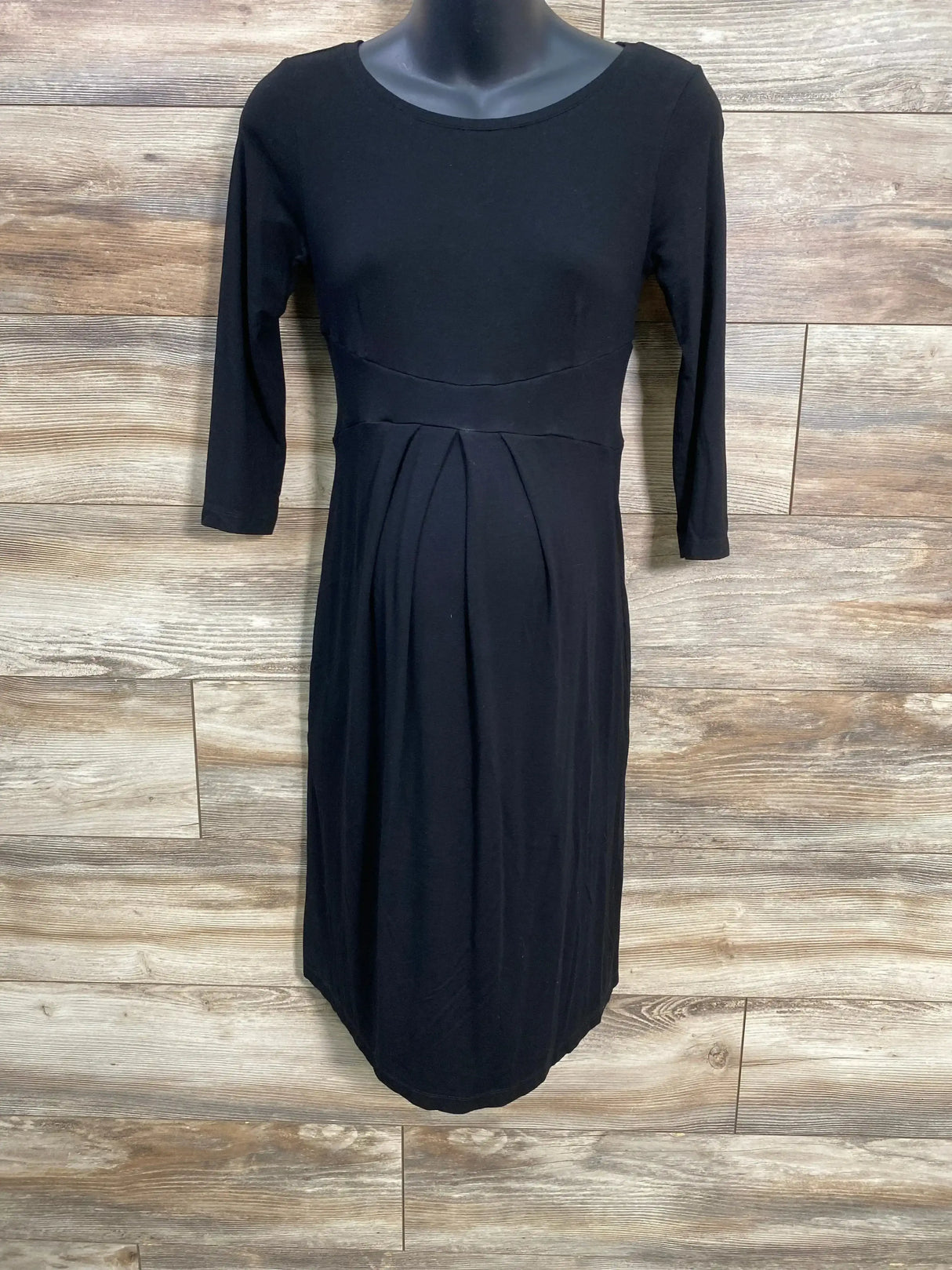 Front view of Isabella Oliver black maternity dress on mannequin showing three quarter sleeves empire waist and front pleats