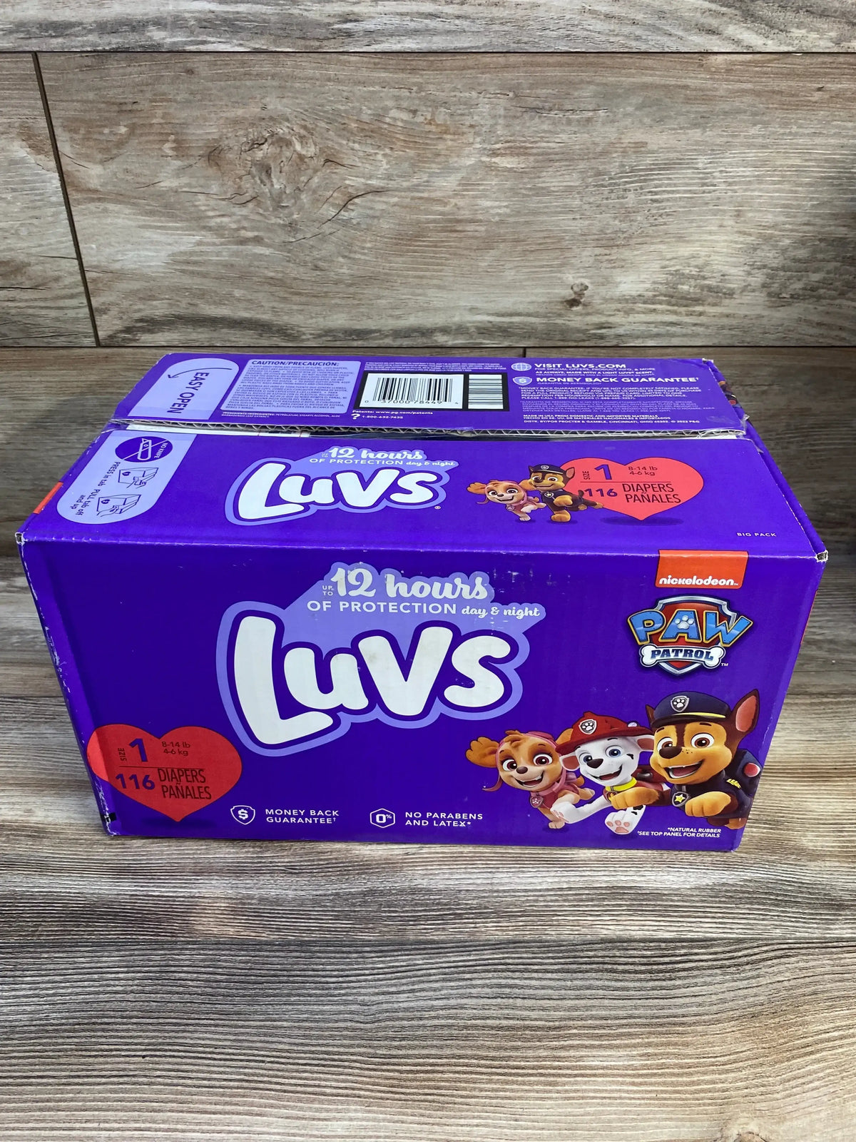 Front view of Luvs Paw Patrol size 1 diaper box showcasing 116-count pack and Paw Patrol characters with wood plank background