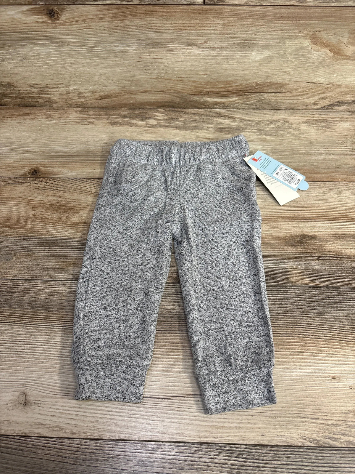 Grey speckled toddler sweatpants with elastic waist and pockets on wooden surface, new with tags