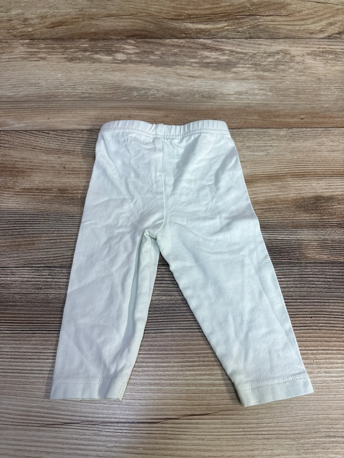 Back view of Burt’s Bees Baby pants in mint, showing an elastic waistband and full-length legs on a wood background