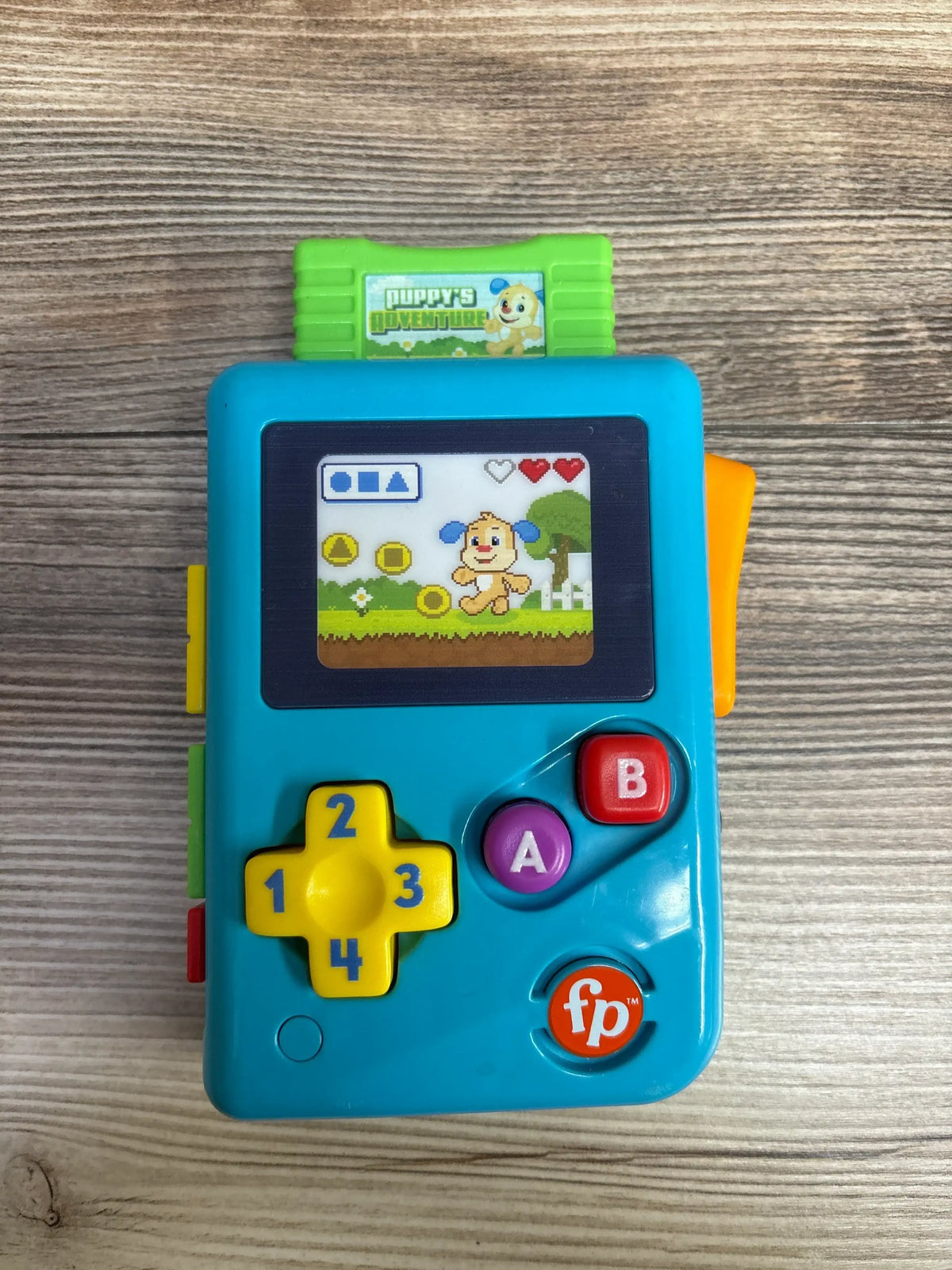 Fisher-Price Puppy’s Adventure blue toy handheld game for kids on wood background
