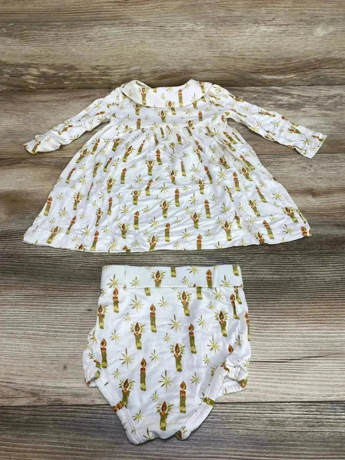 Flat lay of Kate Quinn Candle Peter Pan dress and bloomers showing candle print and Peter Pan collar on wood background