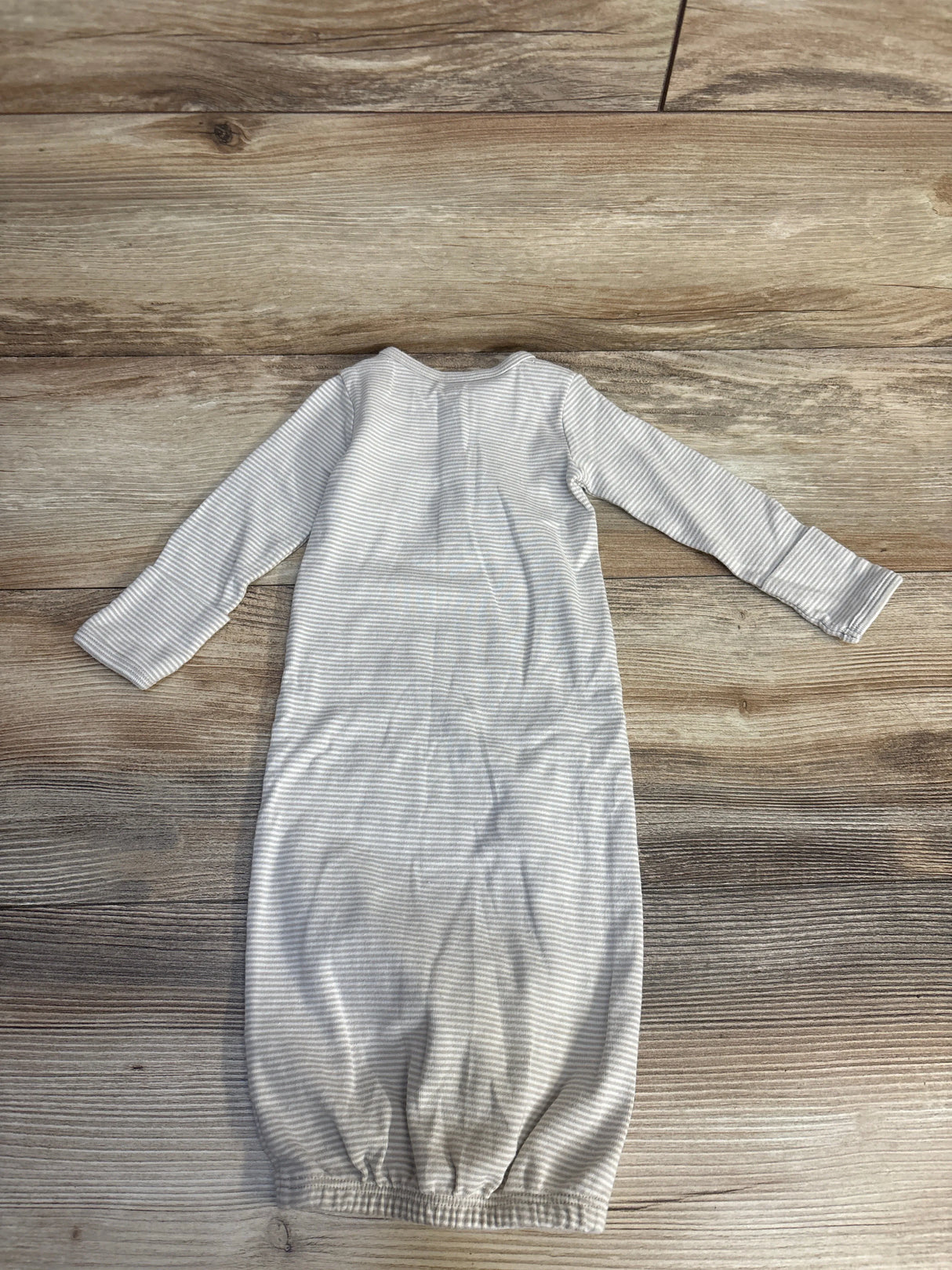 Gray and white striped baby sleep sack on wooden floor