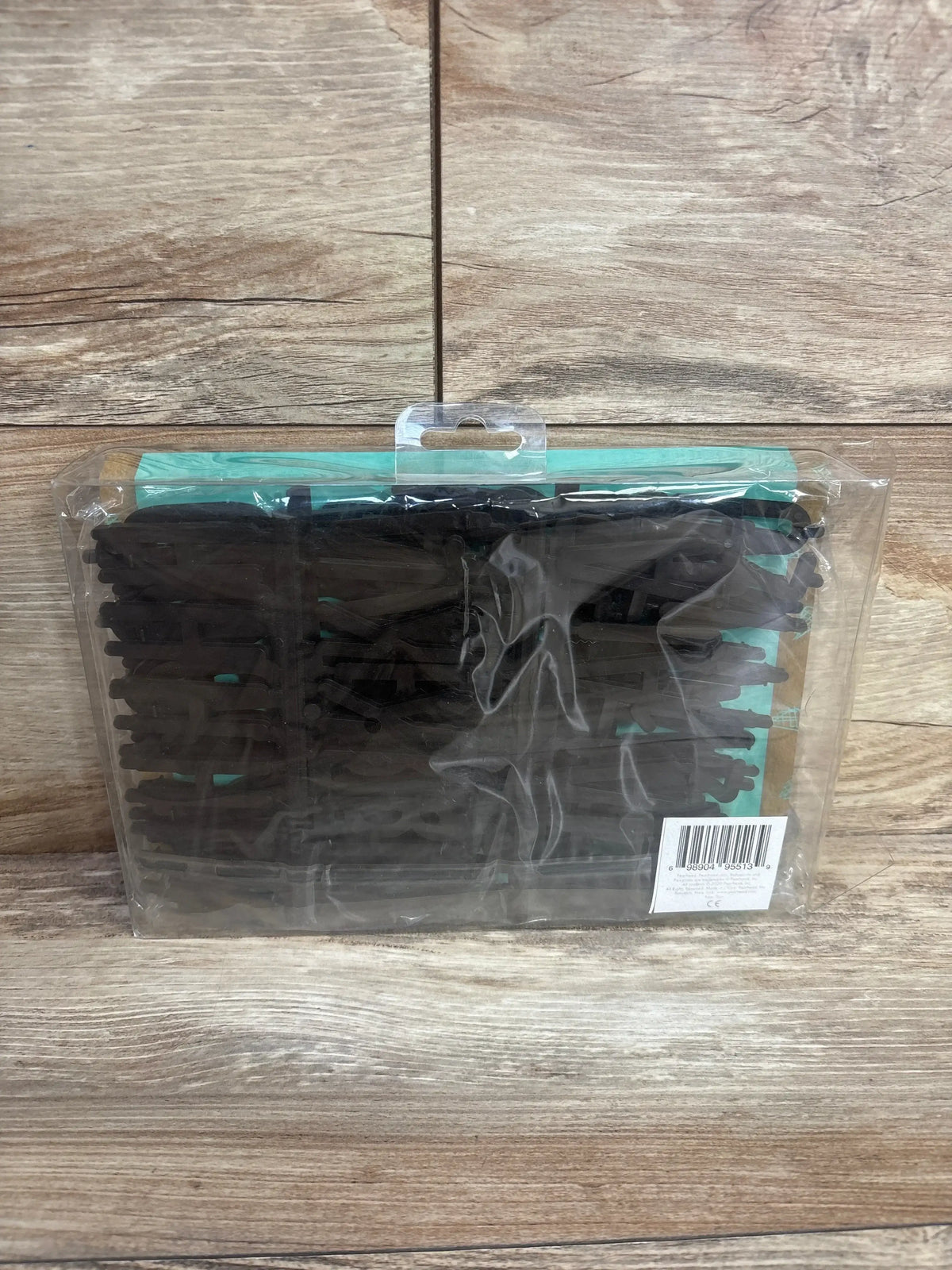 Front view of wooden letter ledge set in clear packaging showing black letters, numbers, and symbols on a wood-grain background