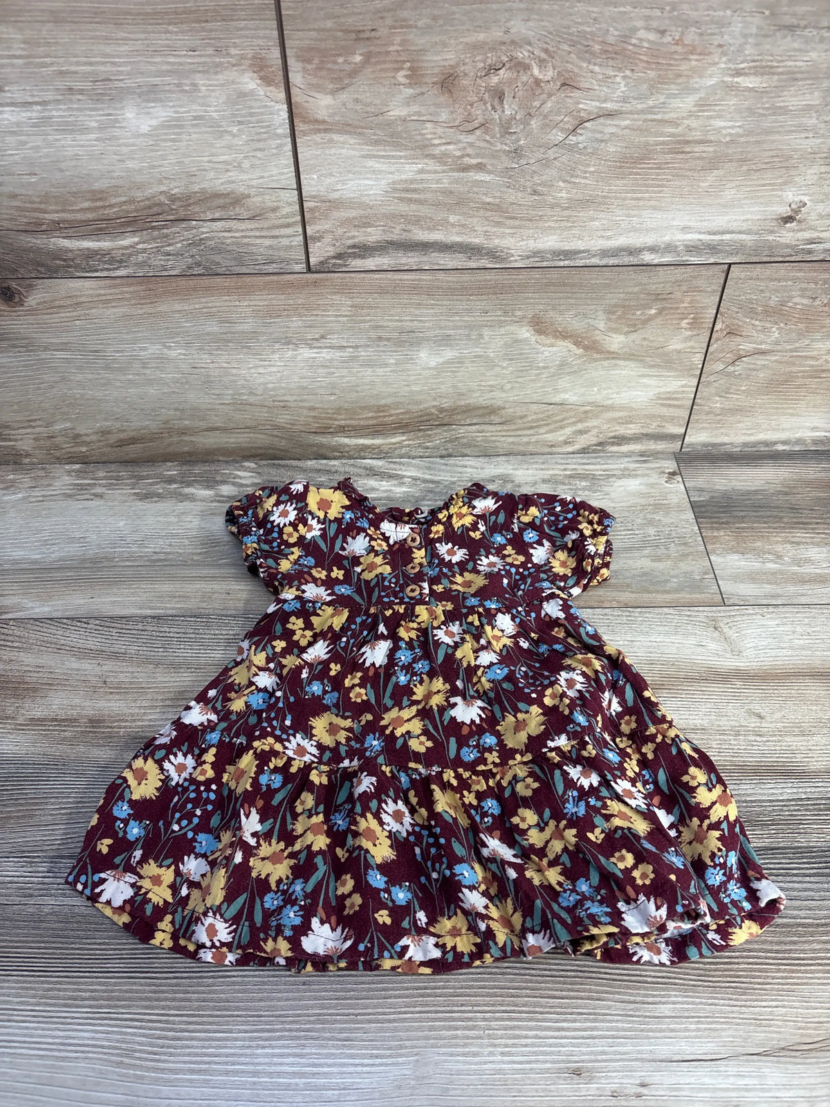 Front view of Wonder Nation floral henley dress showcasing burgundy floral print and henley neckline on wood-look flooring