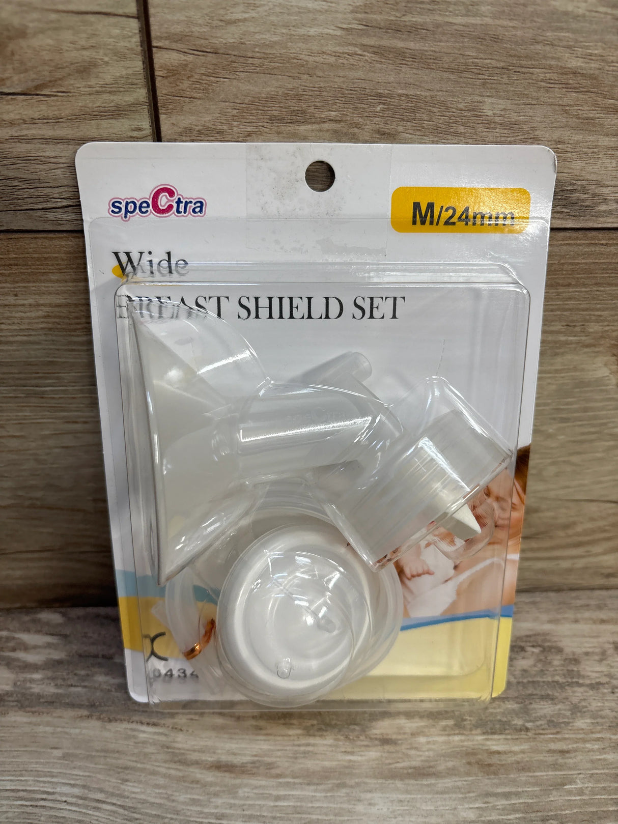 Spectra Wide Breast Shield Set M/24mm in clear plastic packaging on wooden surface