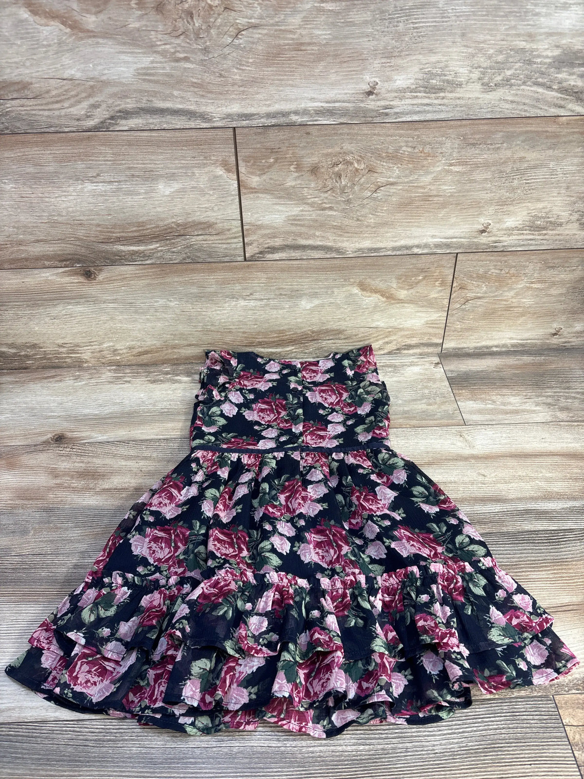 Front view of Janie & Jack navy floral chiffon dress showcasing tiered ruffled skirt on a wood-look floor
