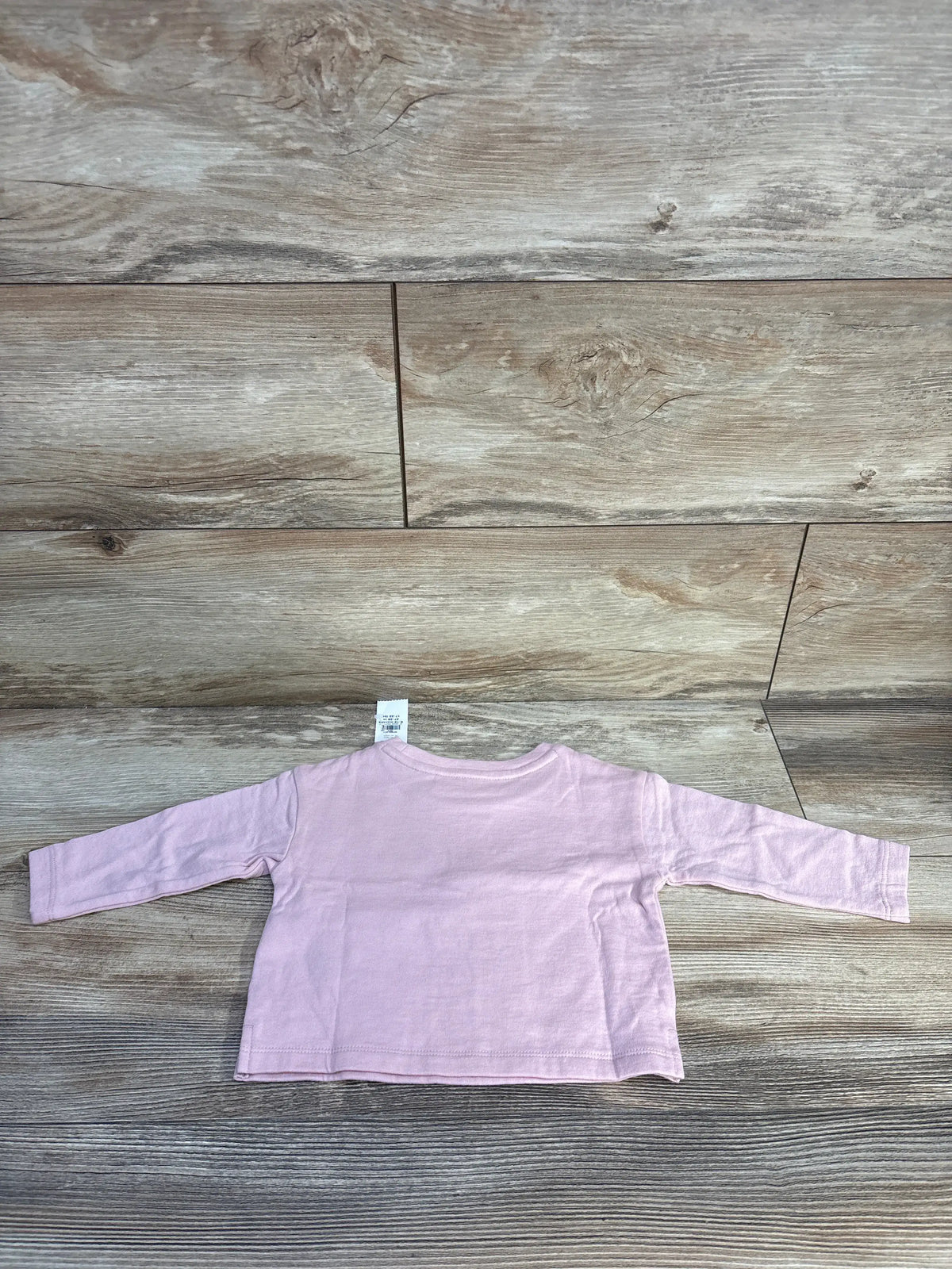 Back view of pink Baby Gap x Disney Minnie Mouse long sleeve shirt showcasing its relaxed fit on wood-look flooring