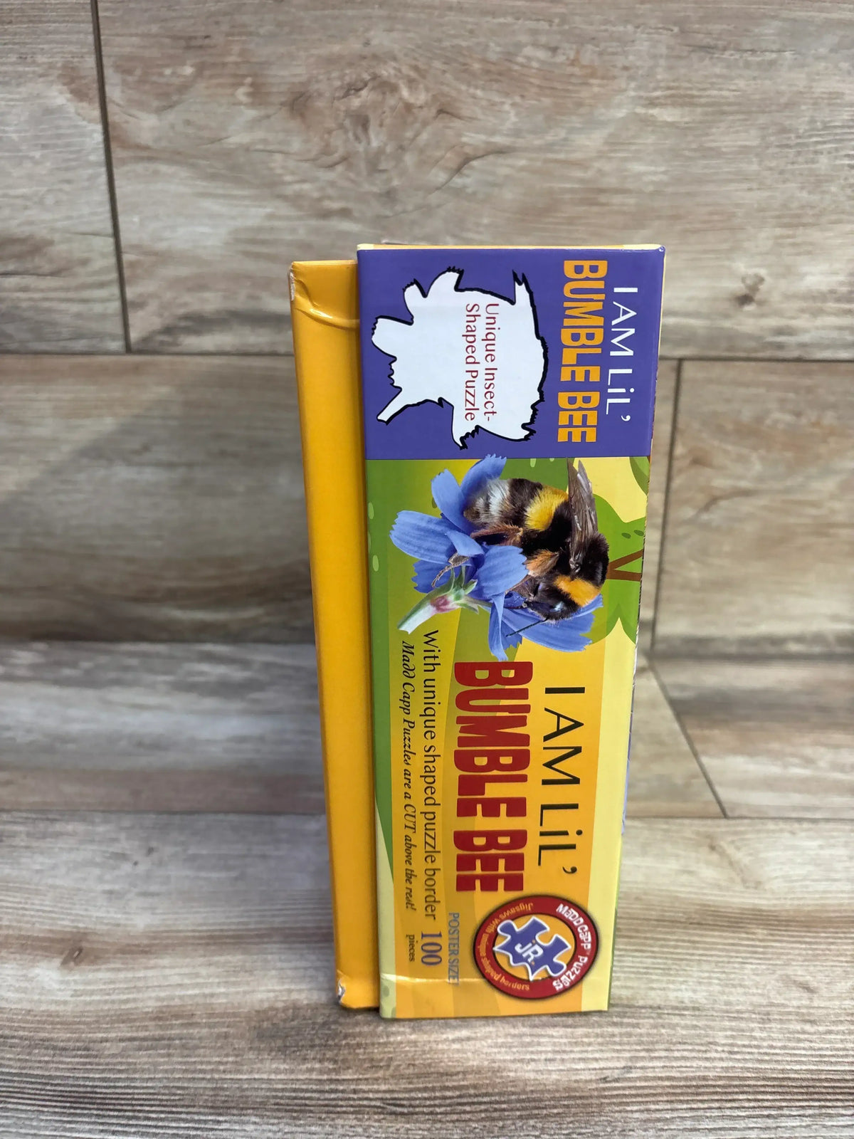 Front view of 100-piece Madd CAPP Lil’ Bumble Bee jigsaw puzzle box showcasing cartoon bumblebee illustration on white background