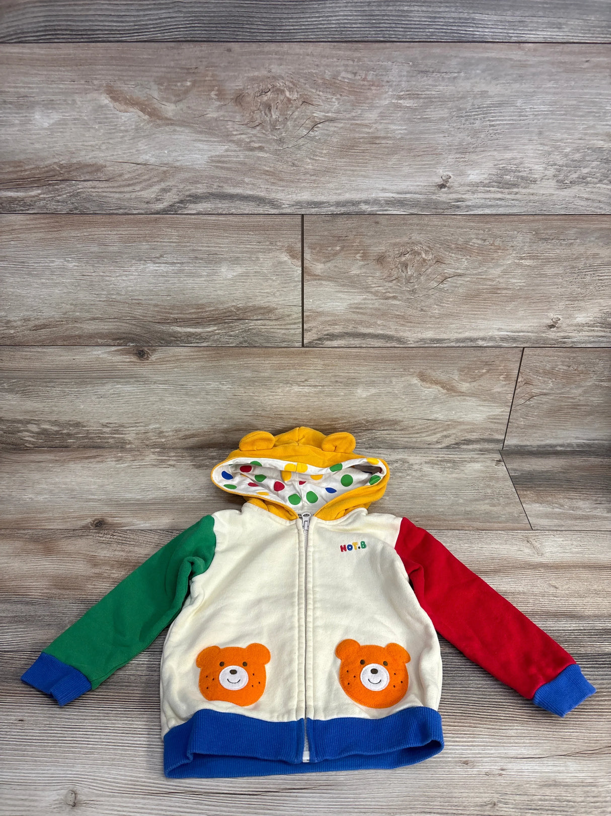 Colorful toddler hoodie with bear face pockets, green and red sleeves, and yellow hood with ears