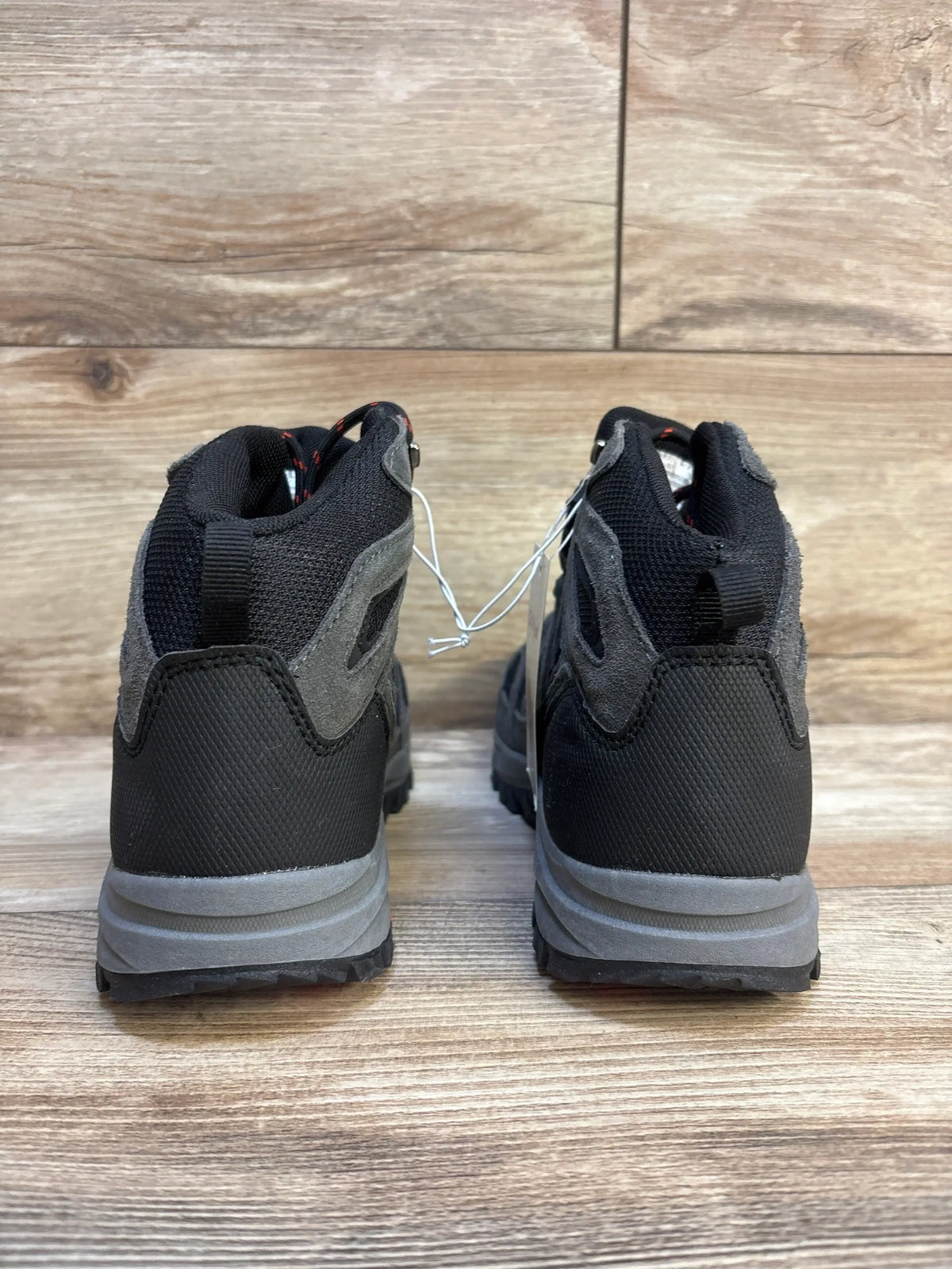 Back view of black and gray children's hiking boots on wood floor