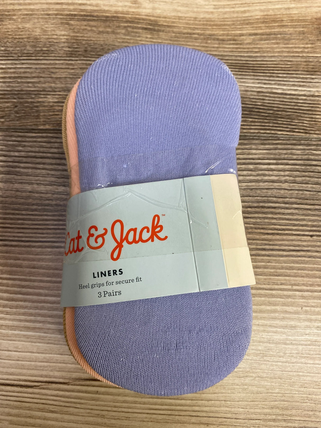 Pack of Cat & Jack liner socks with heel grips, three pairs in pastel colors on wood surface