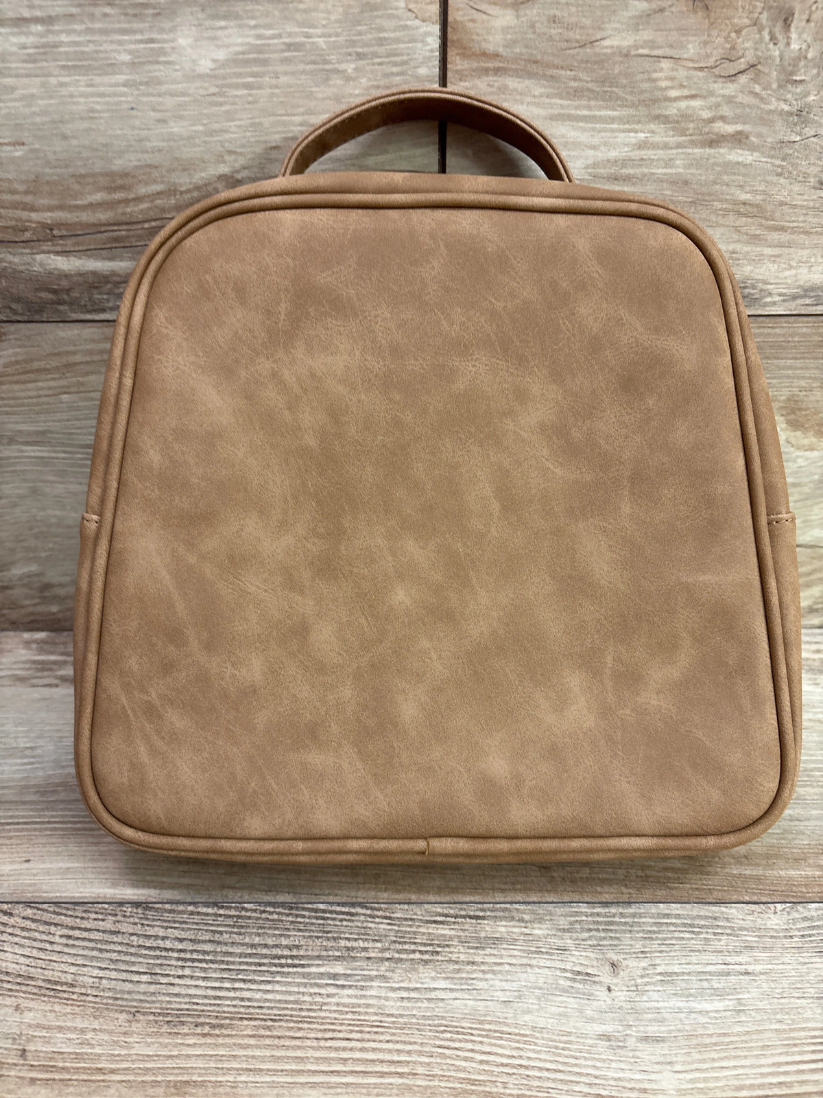 Front view of Petunia Pickle Bottom Tandem Bottle and Lunch Tote showing brown exterior and top handle on wood surface
