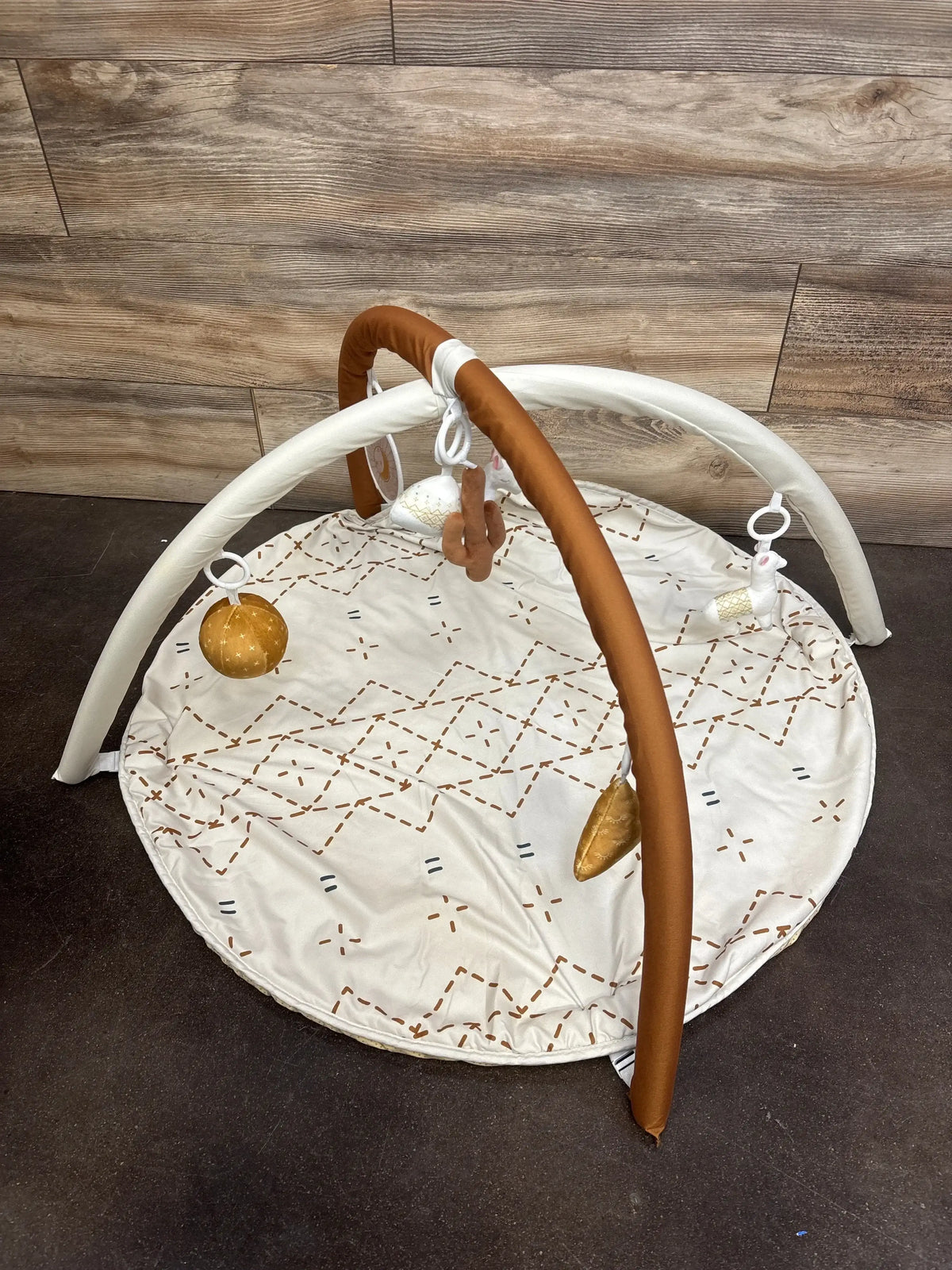 White baby play mat with brown geometric pattern and hanging plush toys, ideal for infant tummy time and sensory play.