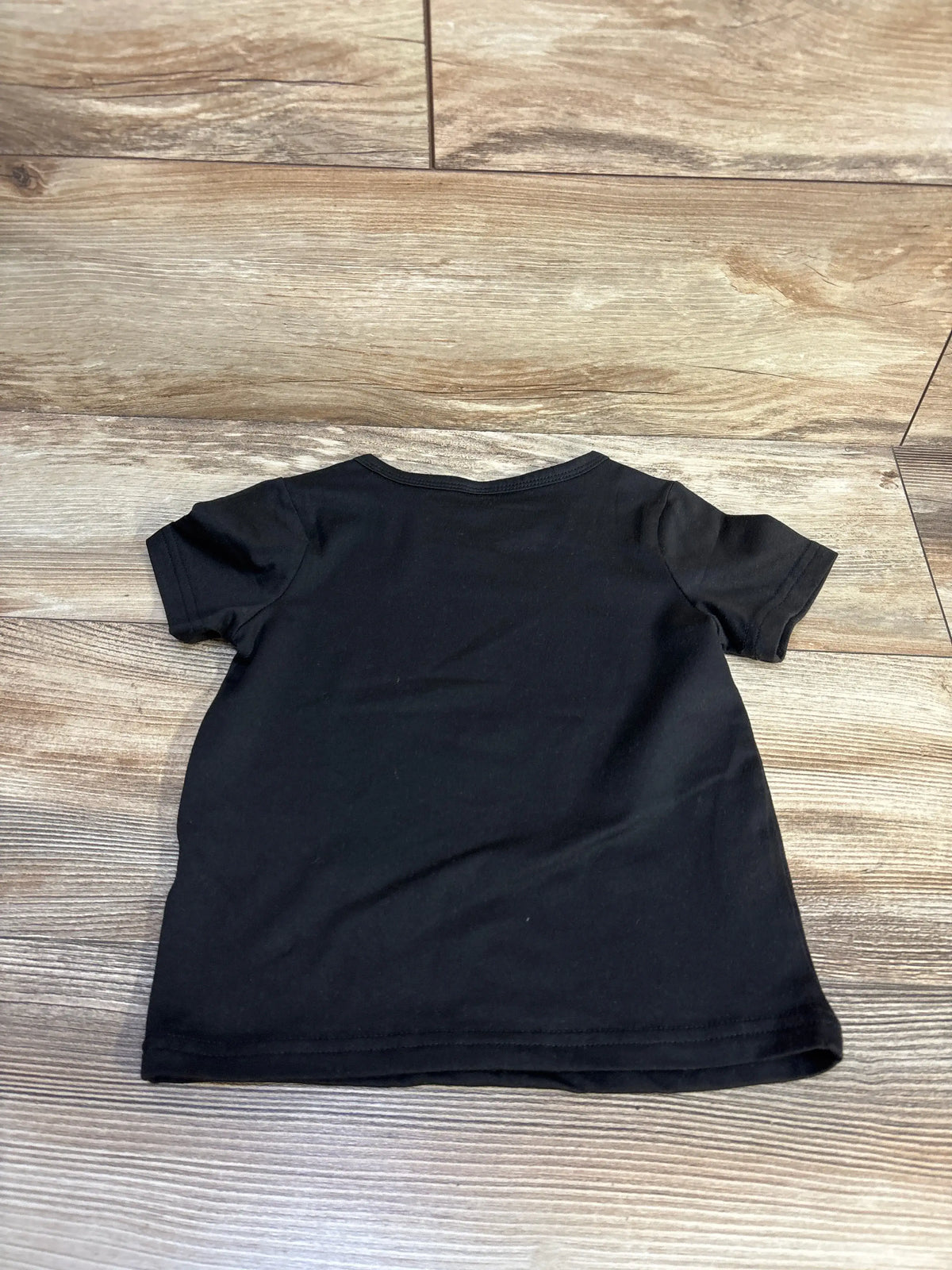 Back view of Shein Little Brother Shirt in black, size 2-3T, showcasing short sleeves on a wood-look floor