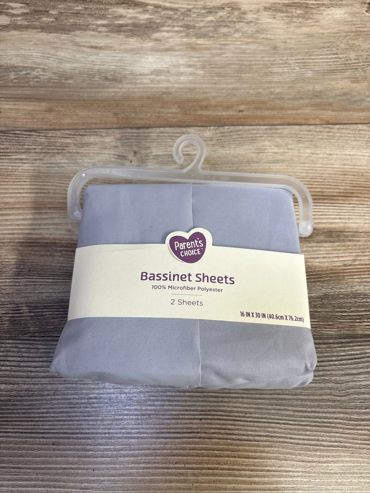 Front view of gray Parents Choice bassinet sheets showing two 100% microfiber polyester sheets 16 by 30 inch size on wood