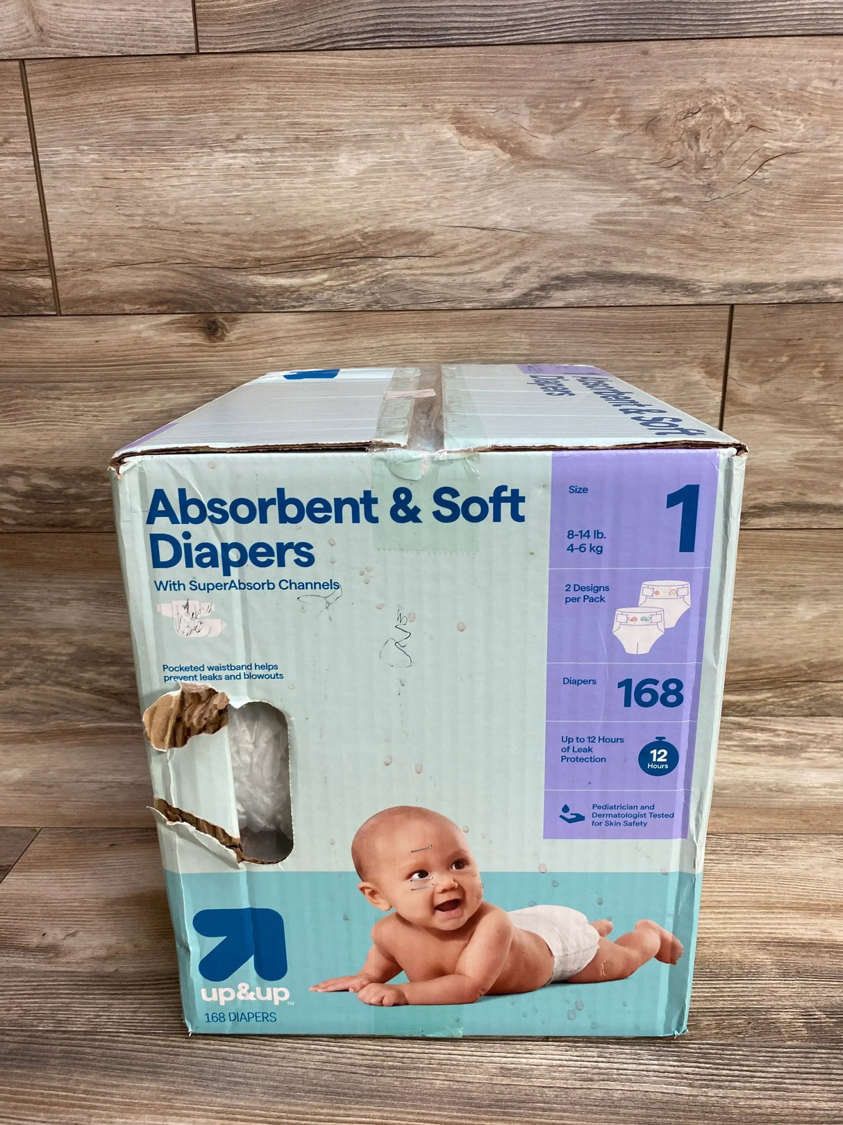 Box of Up & Up size 1 baby diapers, 168 count, with smiling baby on wood floor