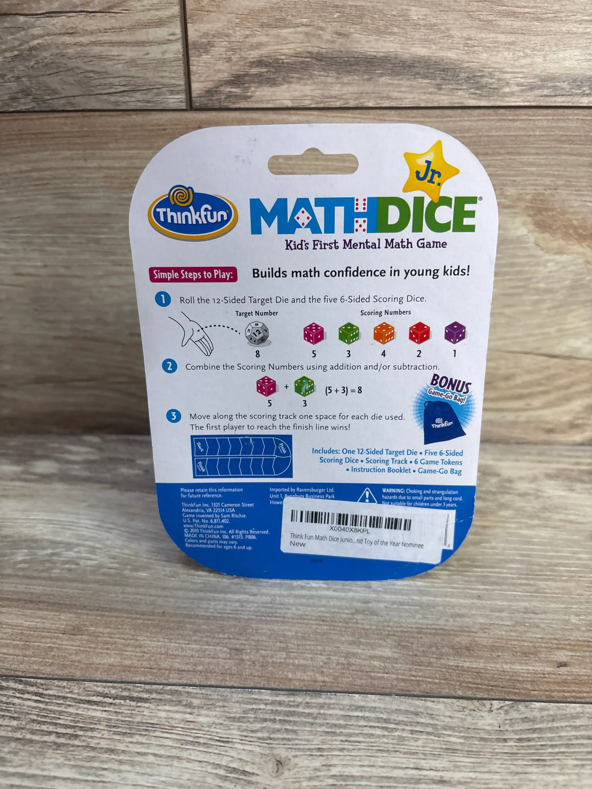 Back view of NEW ThinkFun Jr Math Dice game showcasing dice based math instructions on a wood surface