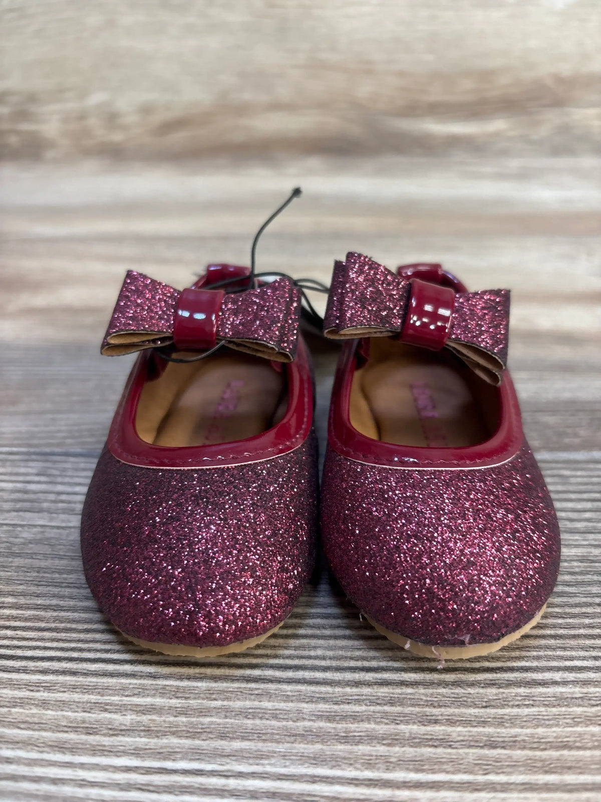 Sparkly burgundy baby girl shoes with bow, perfect for toddler outfits and special occasions.