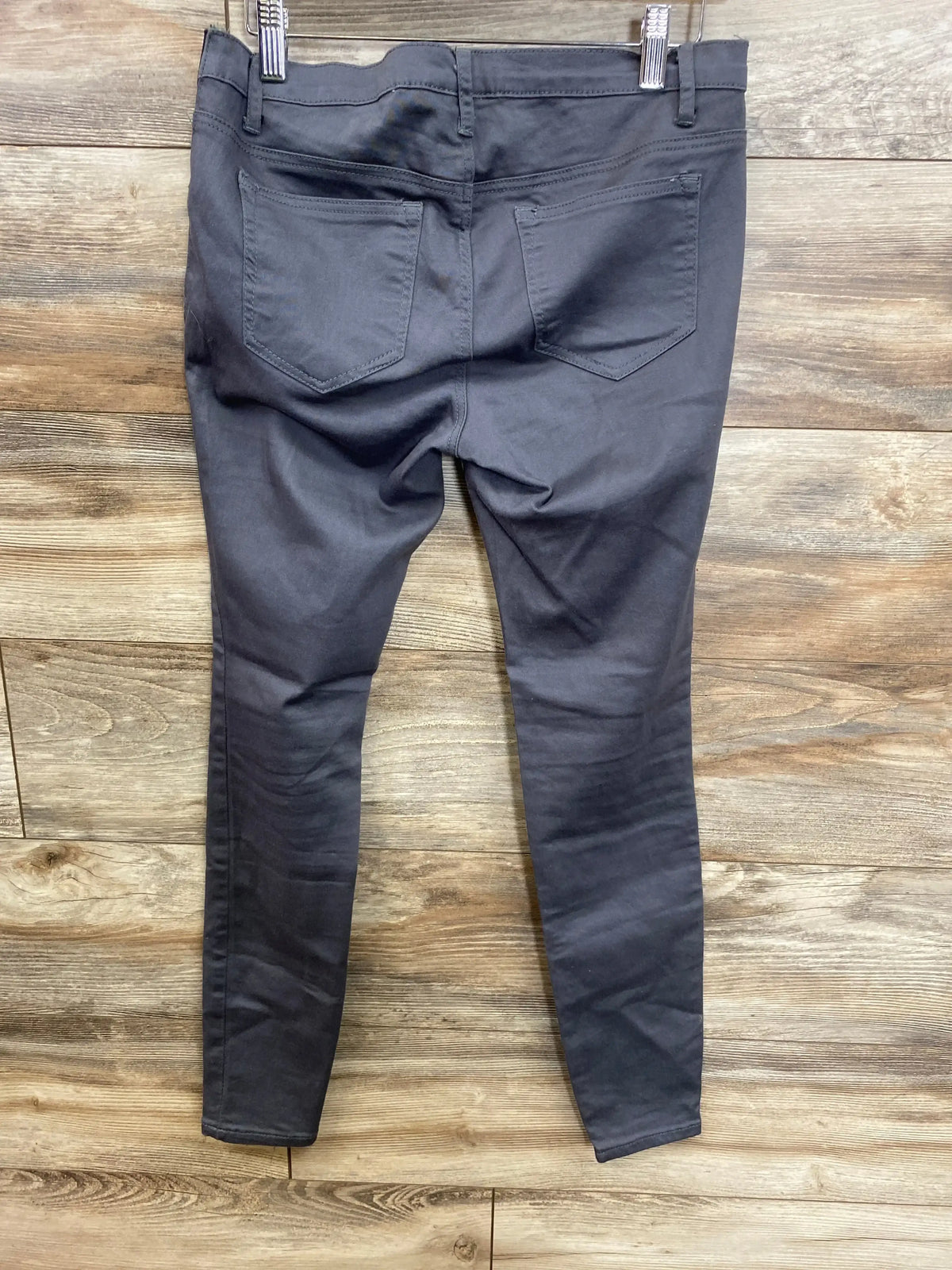 Dark gray maternity pants with back pockets, displayed on wooden background for resale shopping.