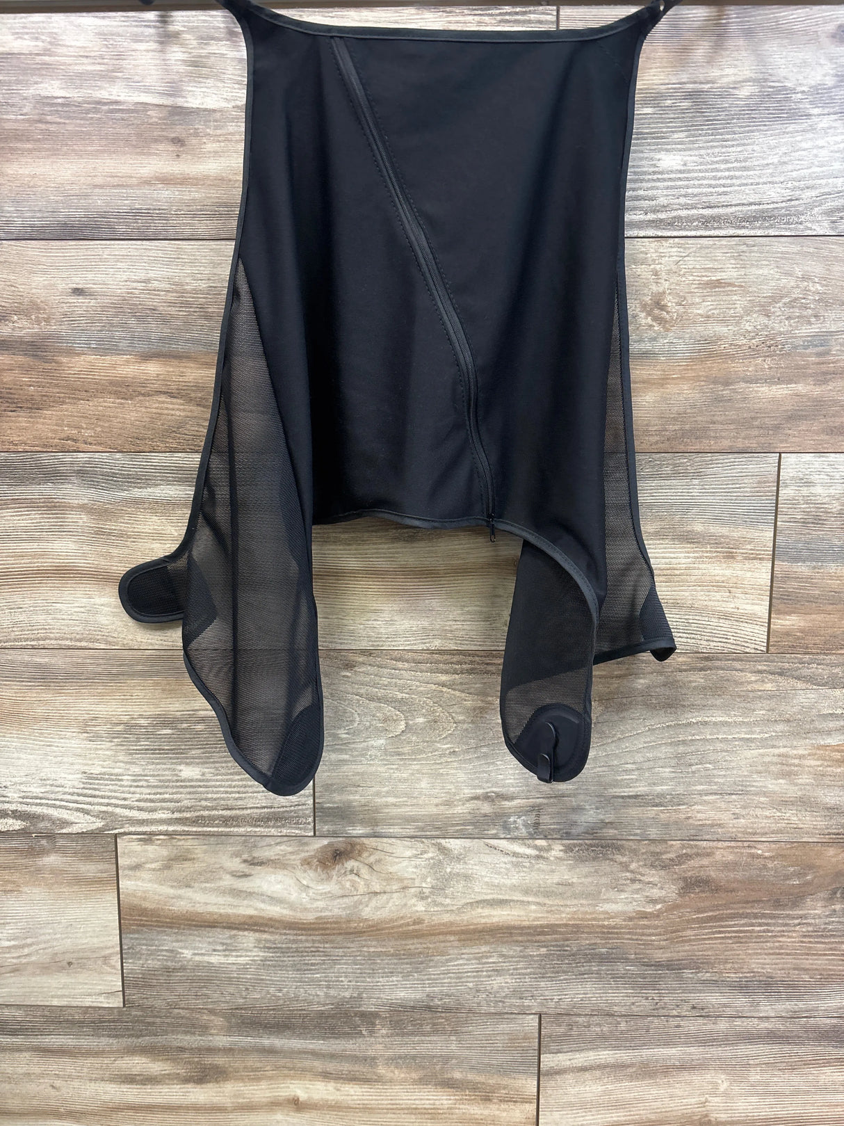 Front view of black stroller sun shade extension showcasing center zipper, mesh side panels, and attachment loops against wood backdrop