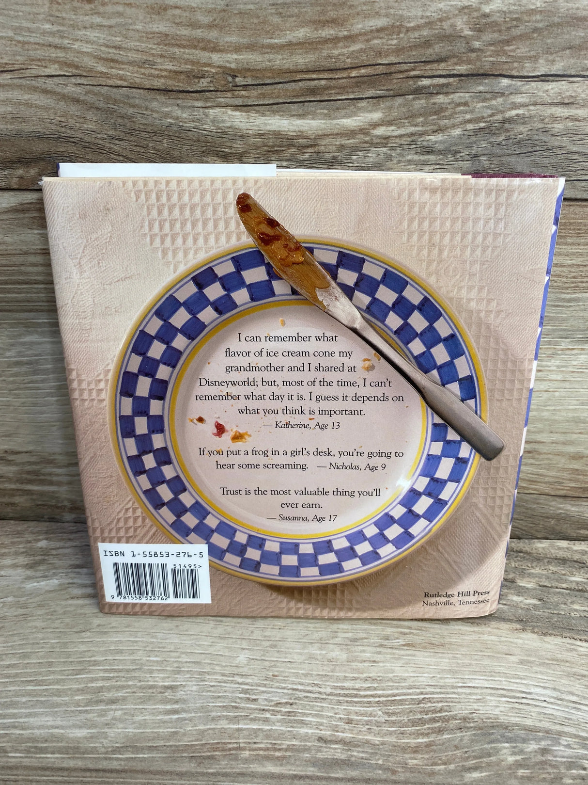 Back of Wit and Wisdom from the Peanut Butter Gang book, checkered plate with quotes and peanut-butter knife on wood