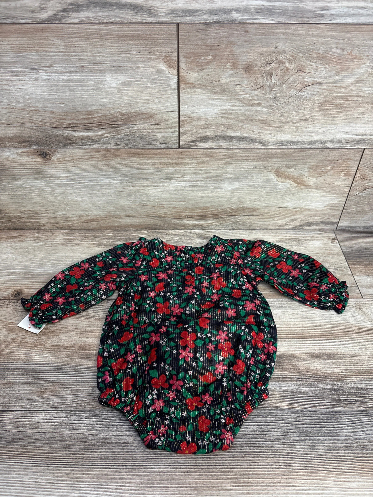 Long sleeve floral baby romper with red and green flowers on a dark background