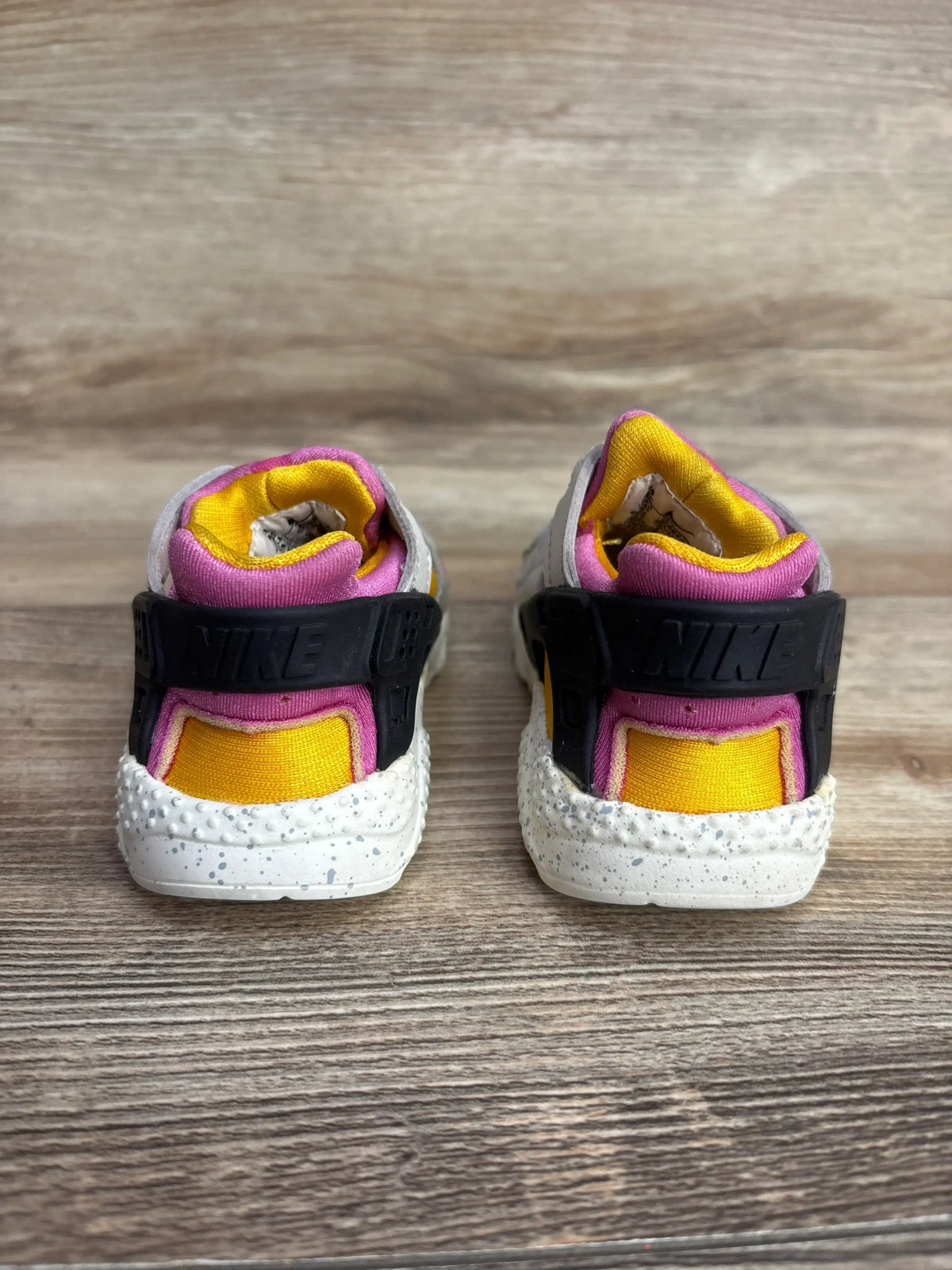 Rear view of Nike Huarache Run TD sneakers Light Bone University Gold Pink sz 5C with black heel strap and pink and yellow lining