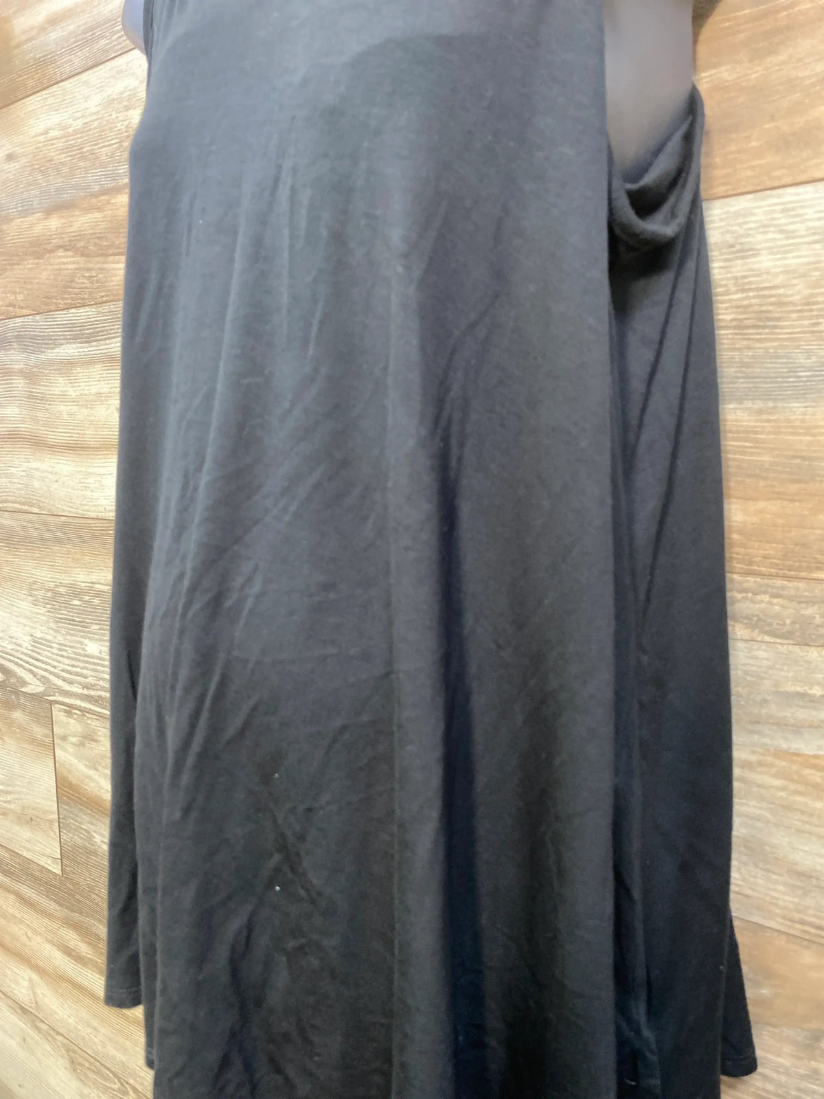 Close-up view of black maternity nursing cami showcasing its sleeveless design with a wood background
