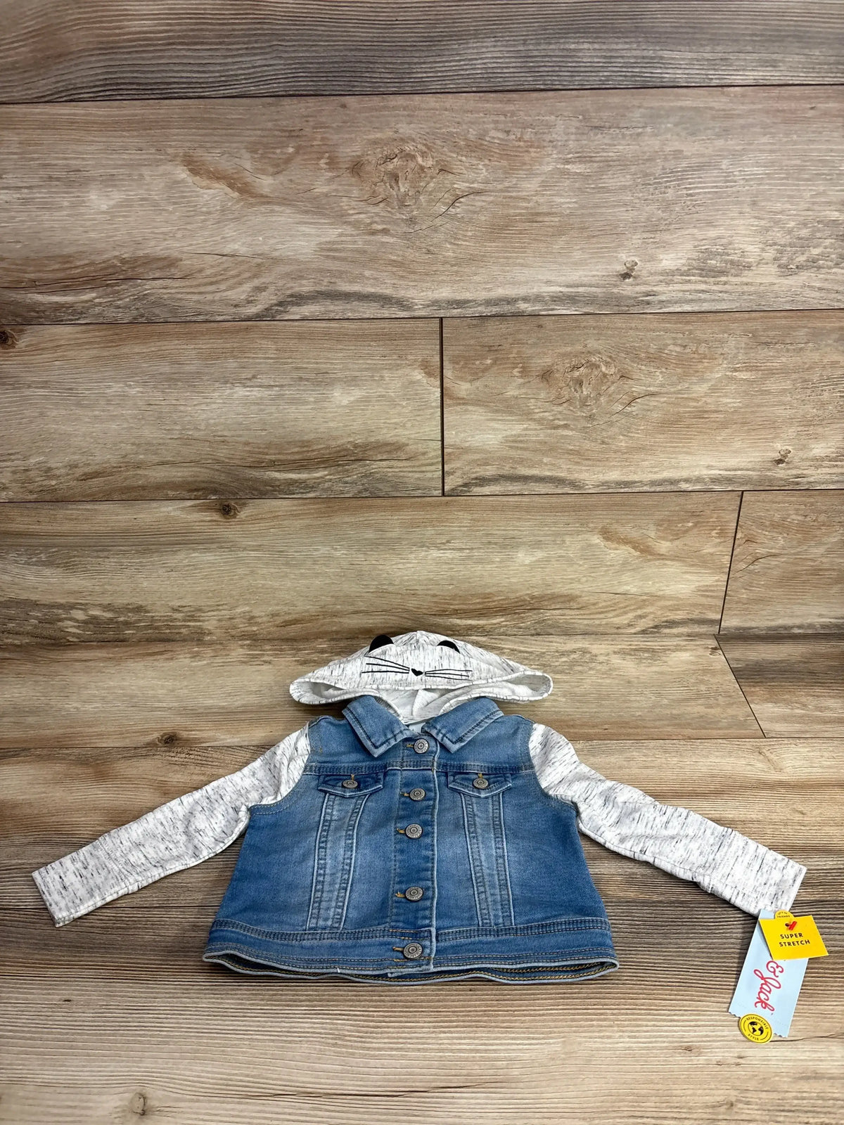 Kids denim jacket with gray hood and sleeves, animal face on hood, laid on wood background